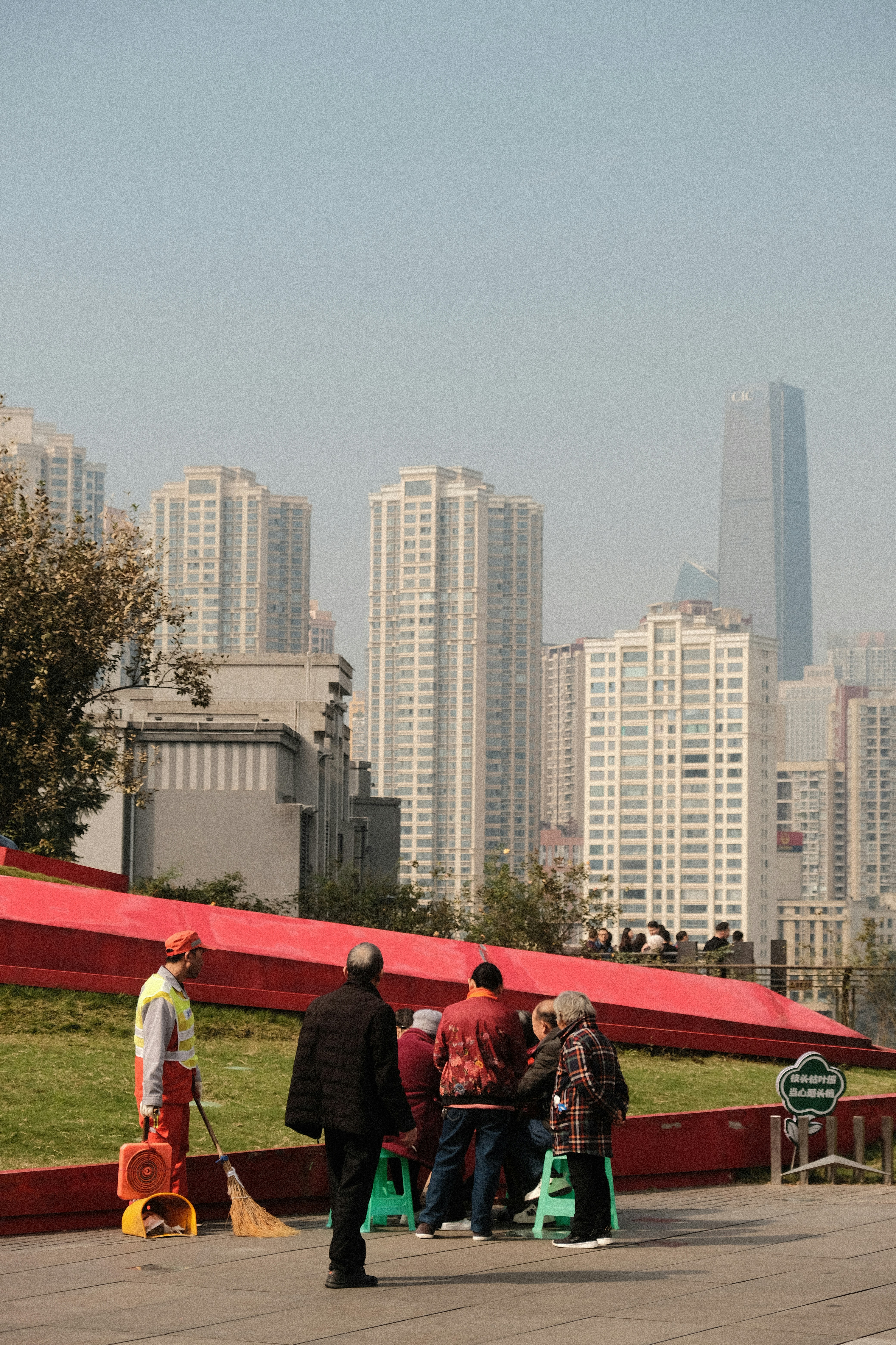 Workers and onlookers gather with city buildings in background