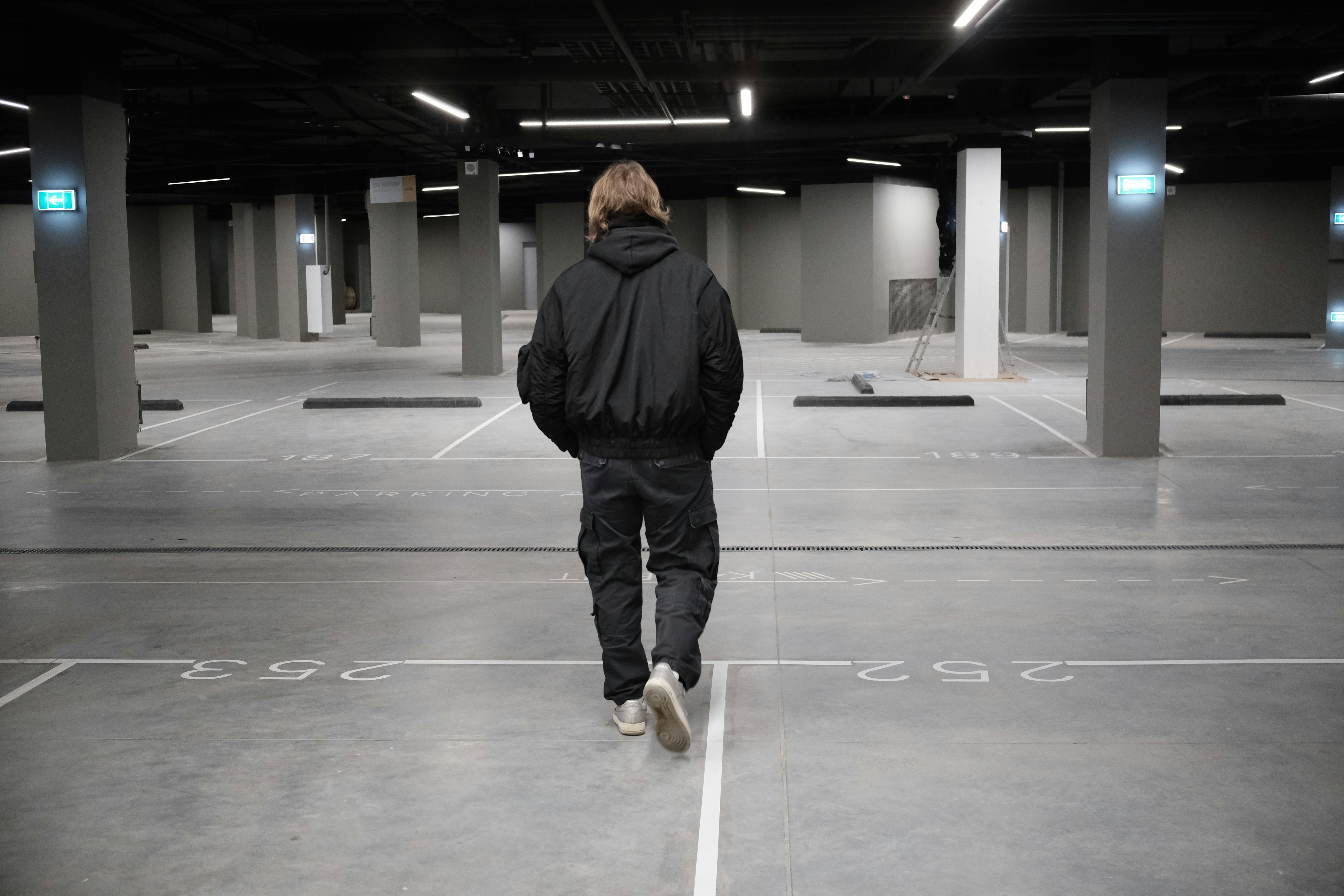 Person walking in an empty parking garage.