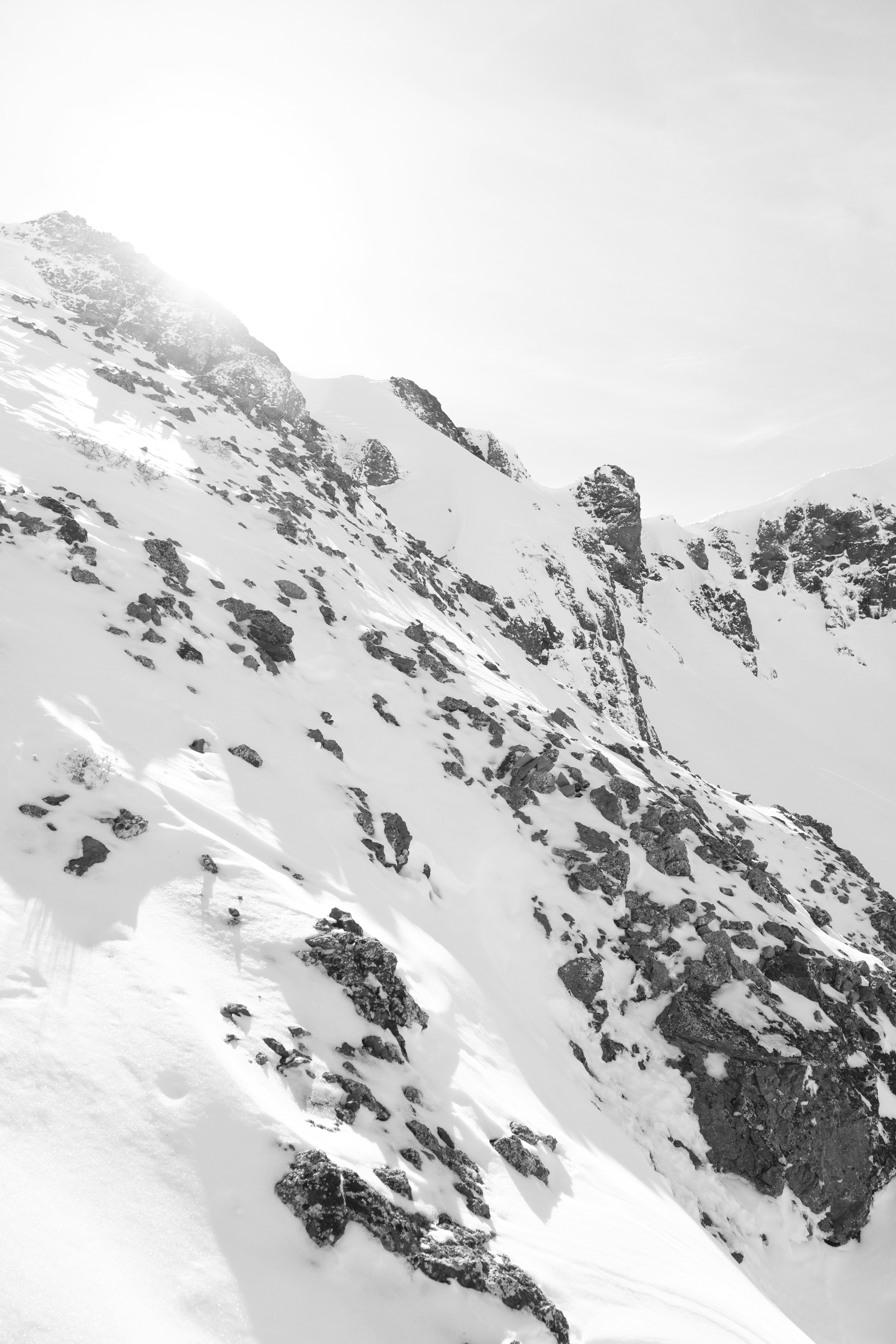 Snow-covered rocky mountain range under bright sunlight