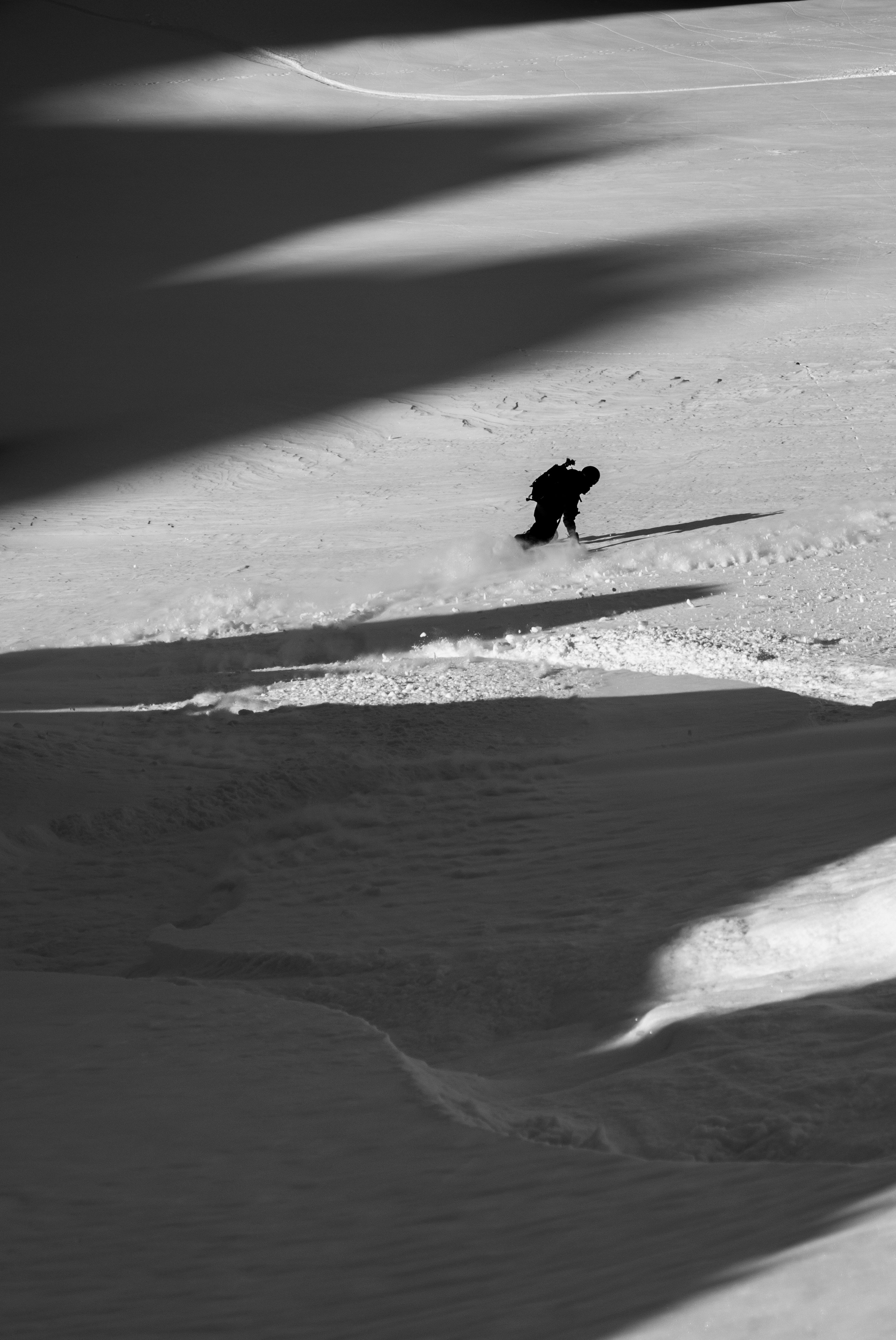 Snowboarder carving a turn on a snowy slope.