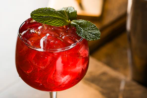 A refreshing red cocktail with mint garnish