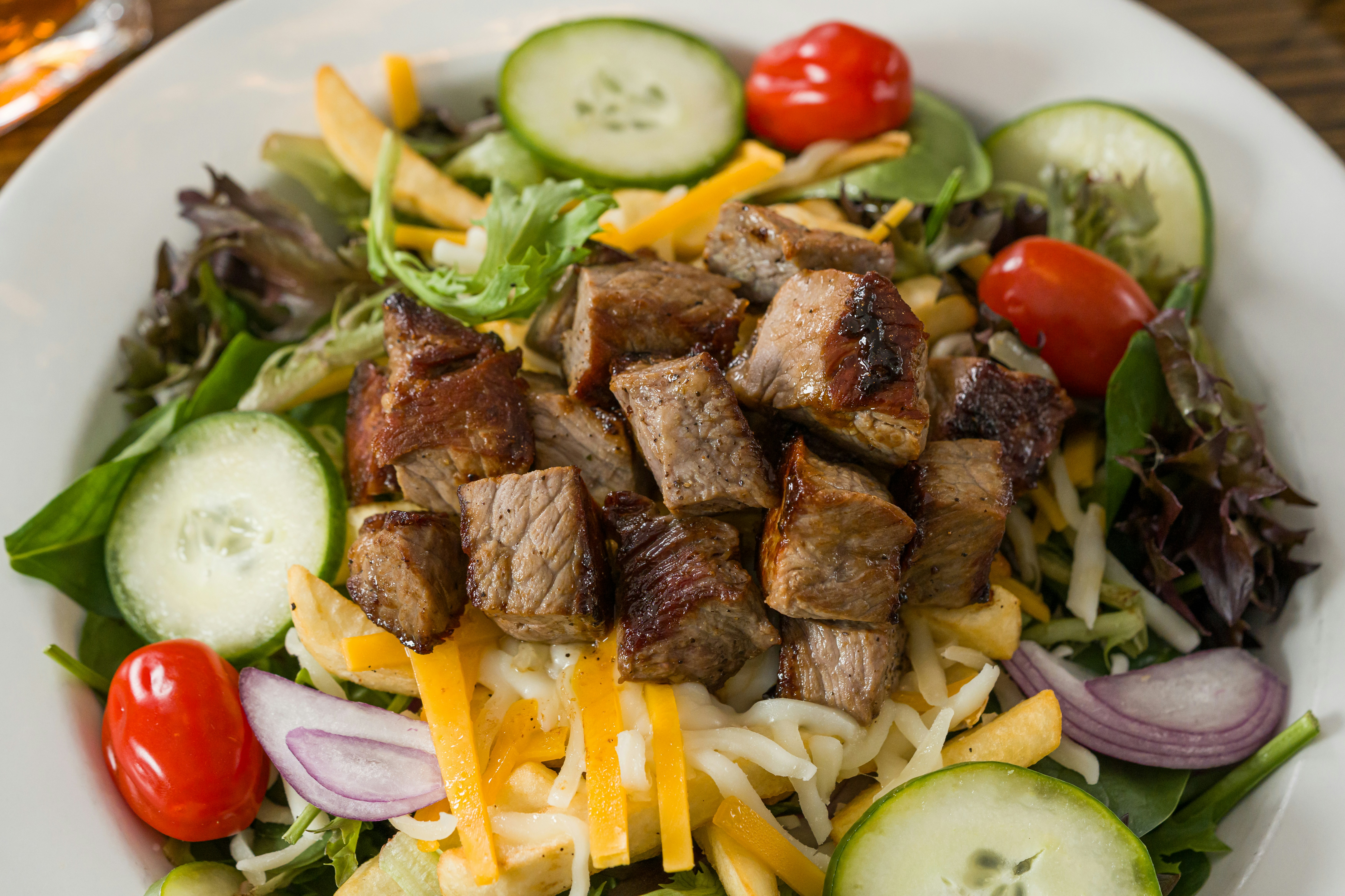 Steak salad with cucumbers, tomatoes, and cheese