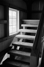 Wooden stairs leading up next to a window