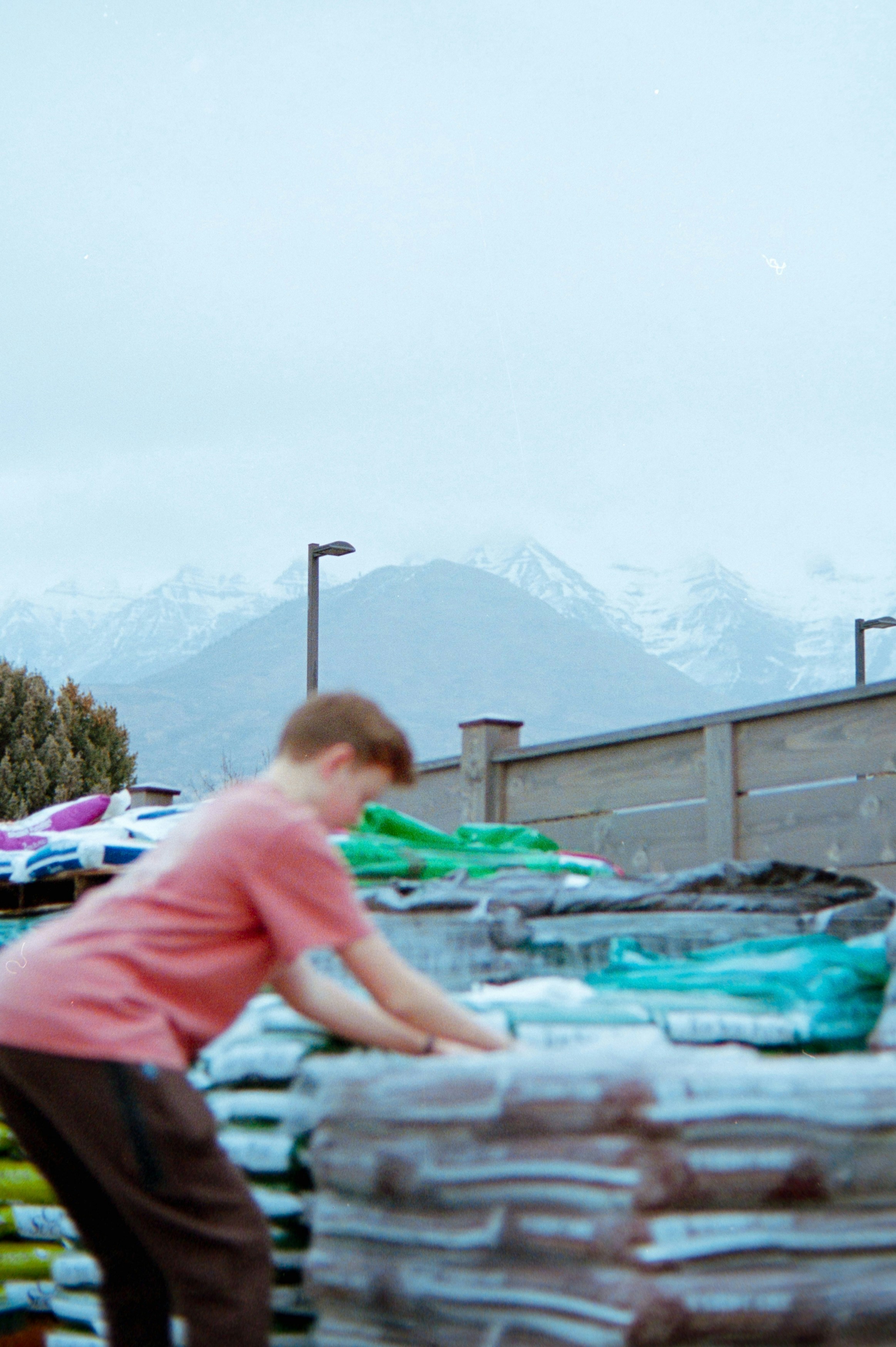Boy stacking bags with mountains in background