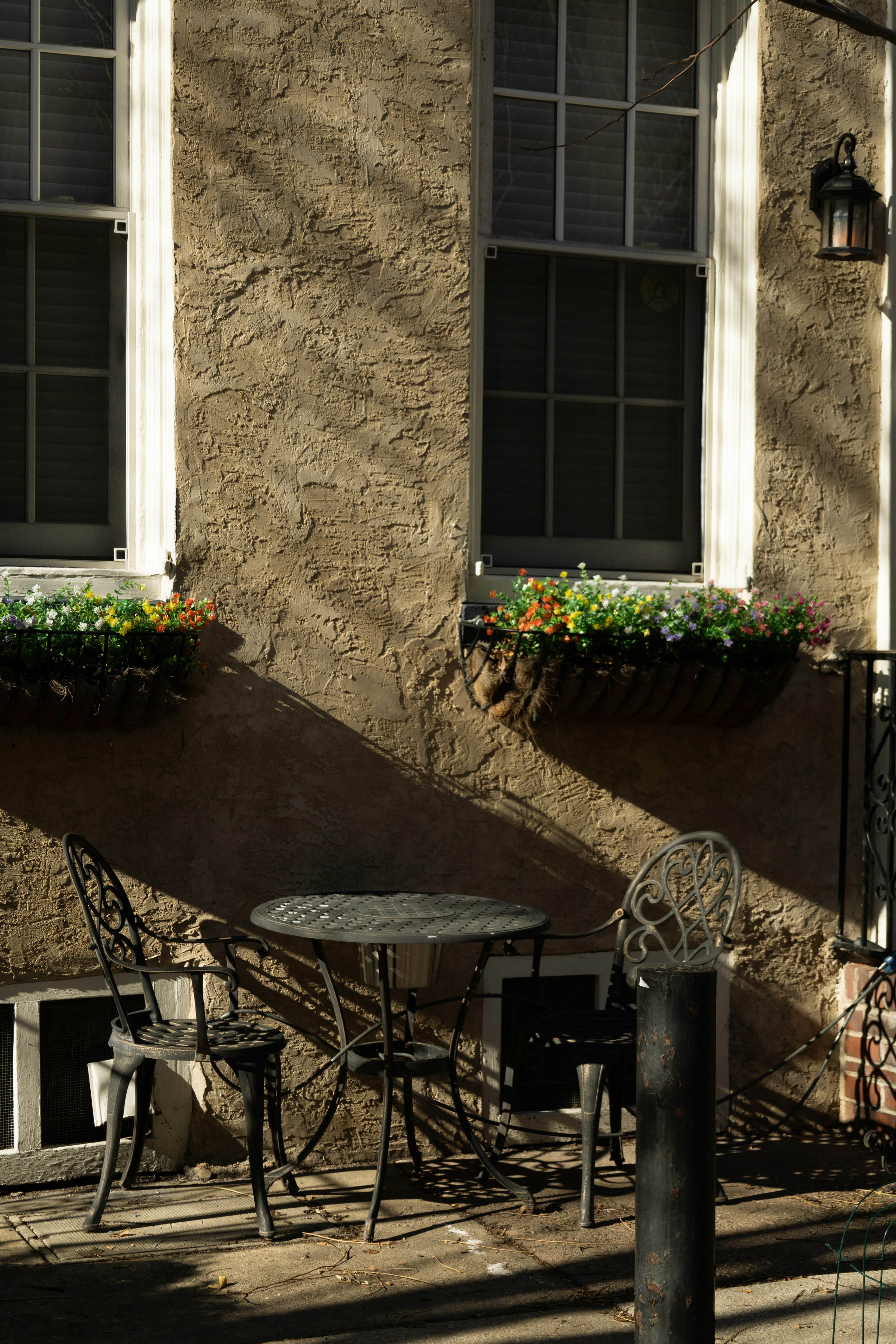 Two chairs and a table on a sunny patio.