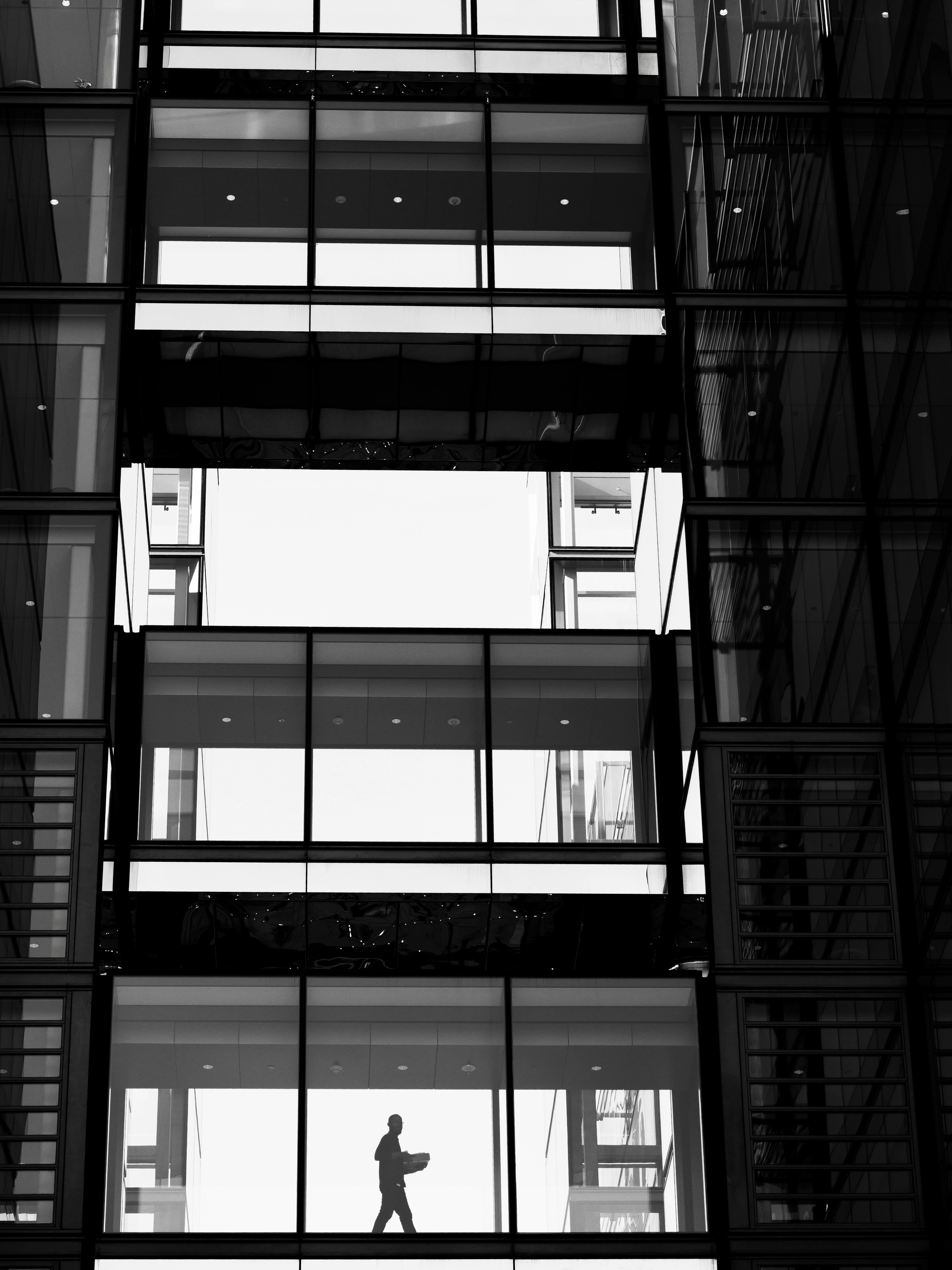 Silhouette of a person walking with a laptop.