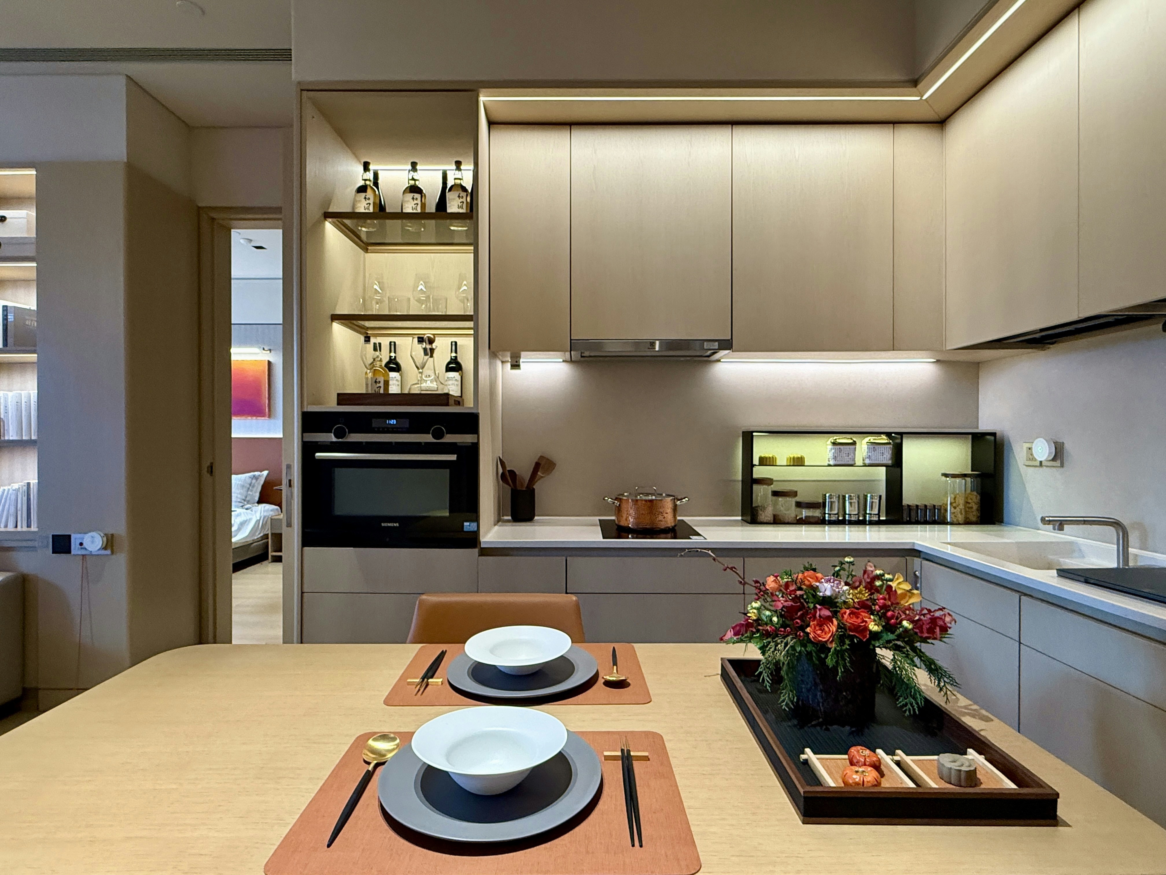 Modern kitchen with dining area and floral centerpiece.
