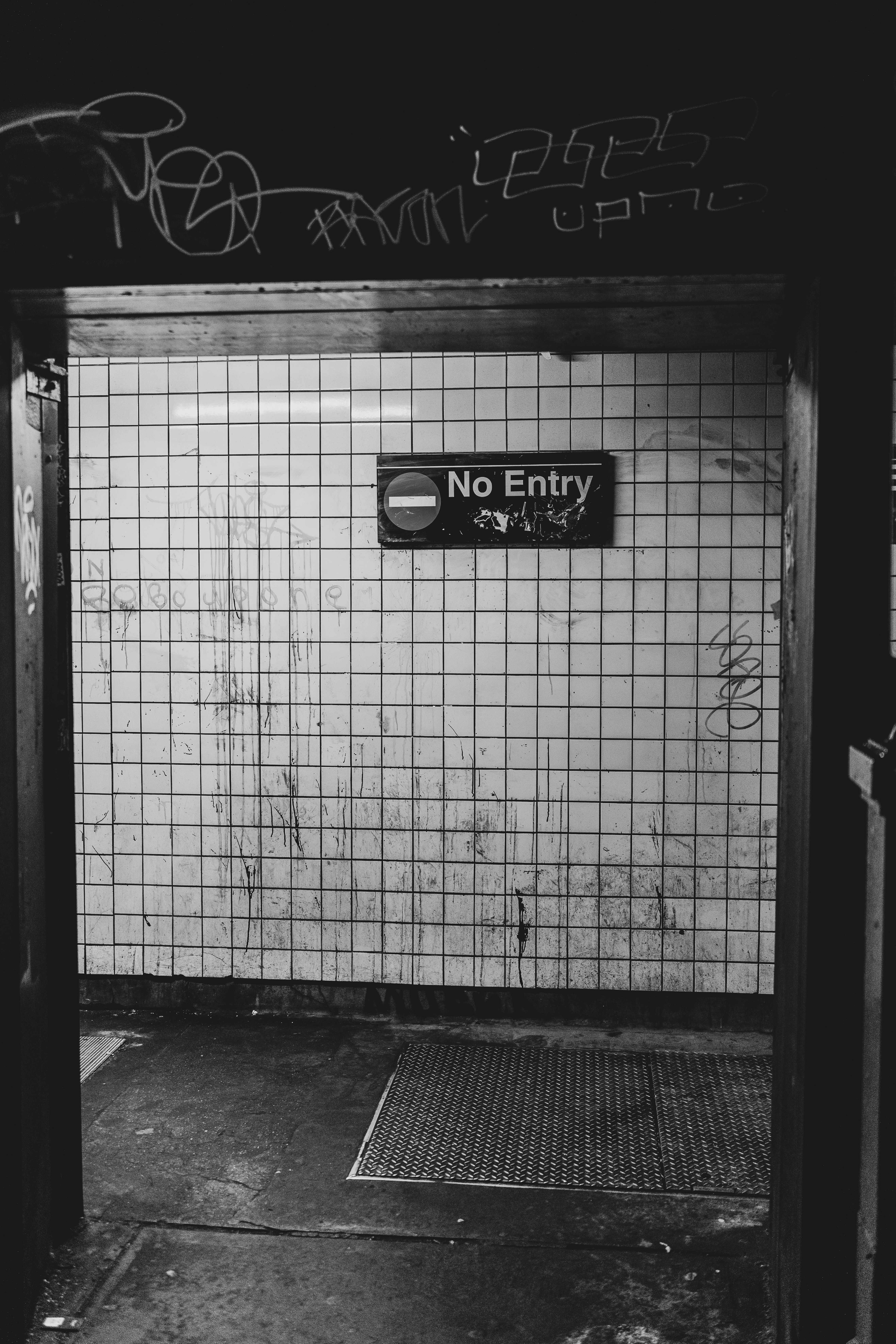Entrée de métro sale avec un panneau d’interdiction.