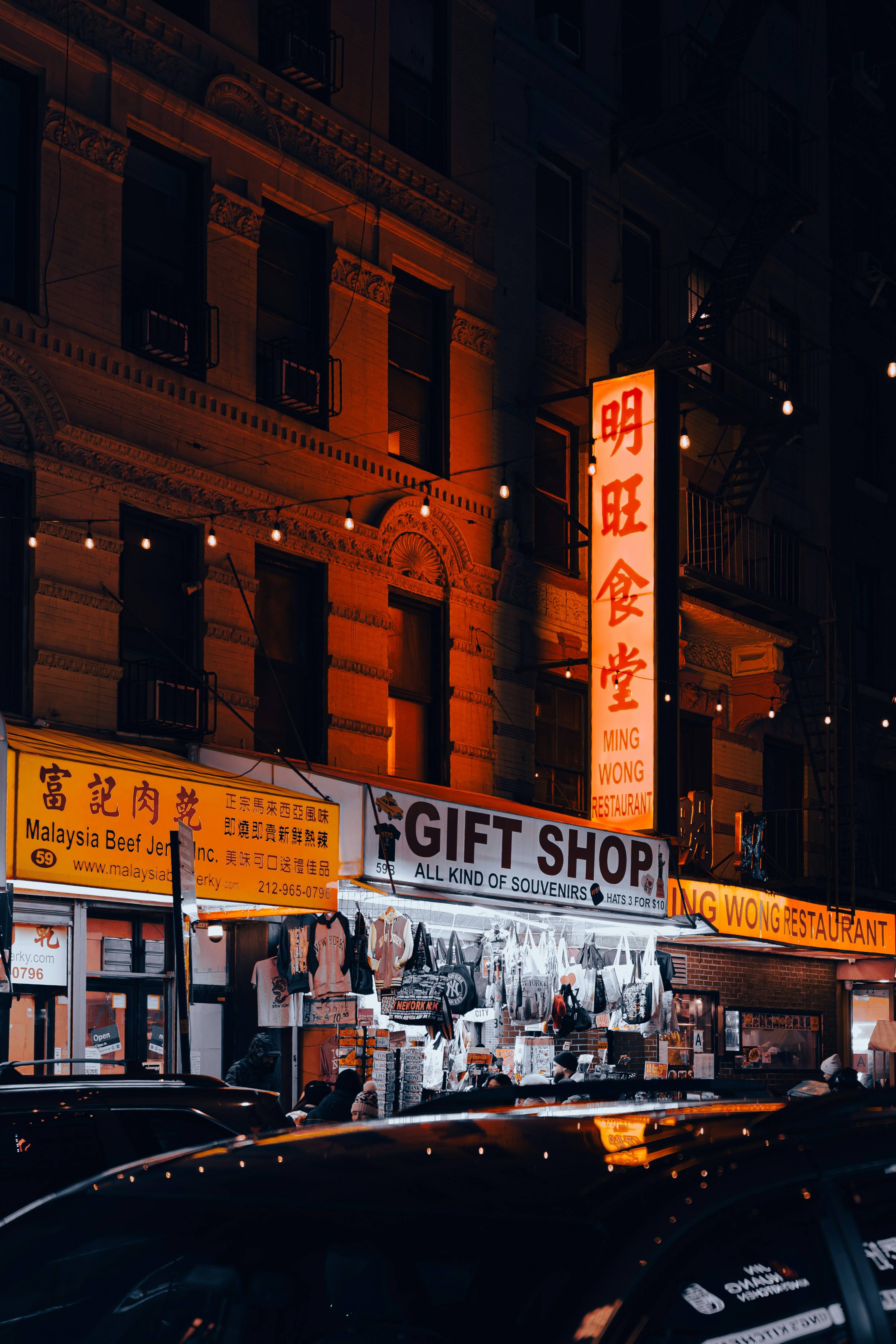 La rue de la ville la nuit avec des boutiques et des enseignes illuminées.