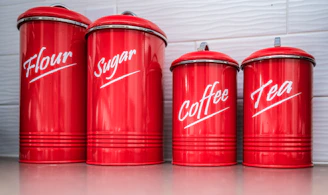 Four red retro canisters labeled flour, sugar, coffee, tea