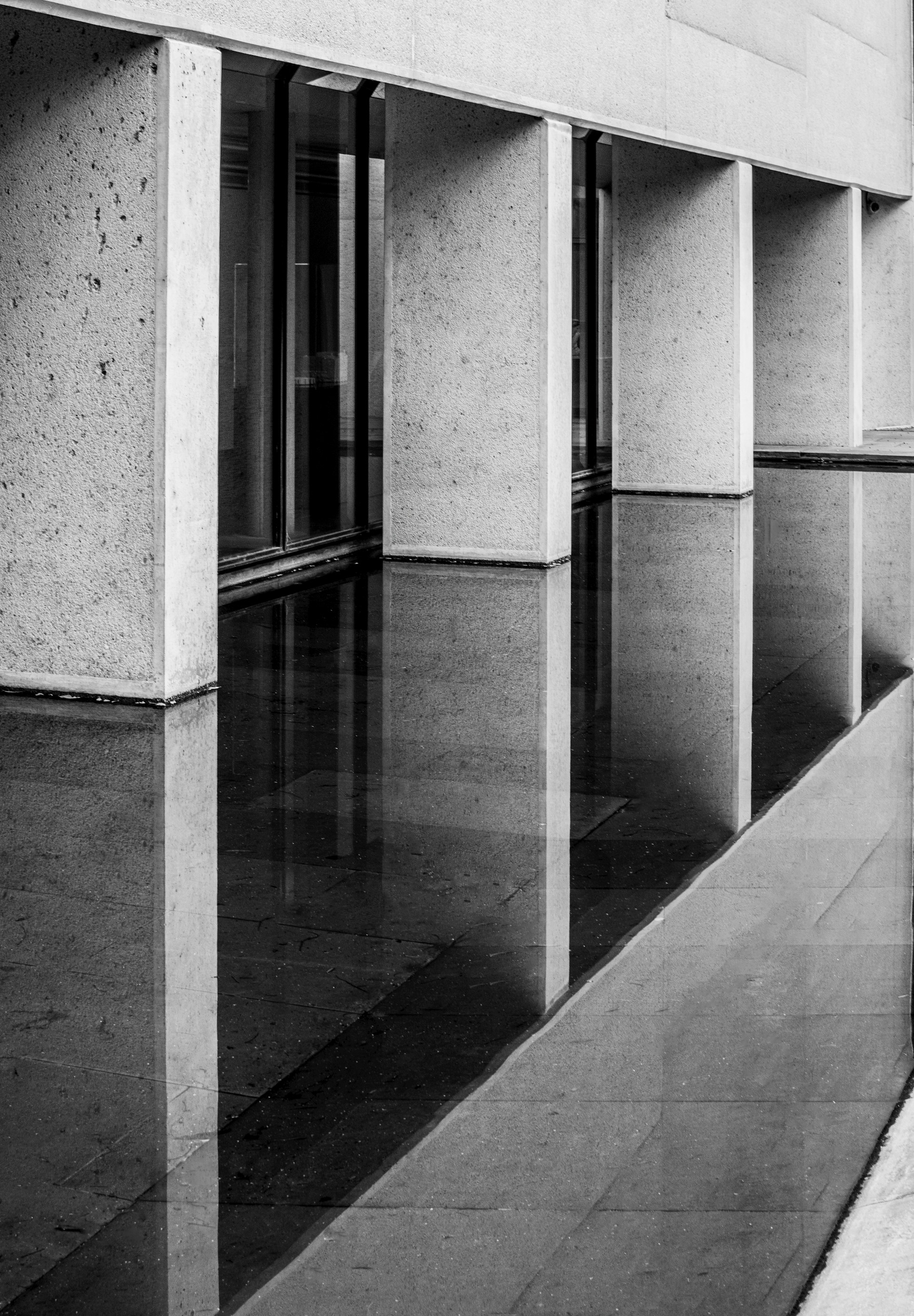 Modern architectural columns reflected in still water