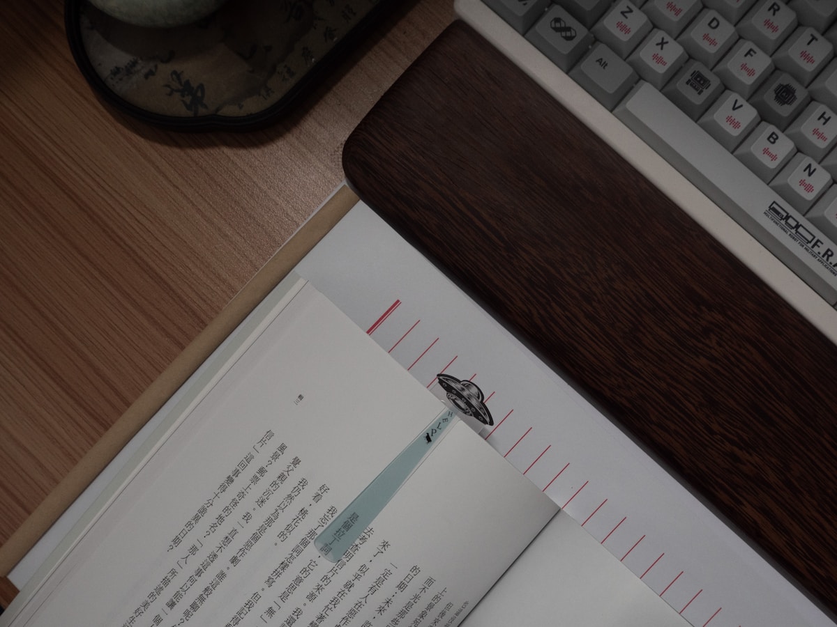Open book with bookmark next to keyboard
