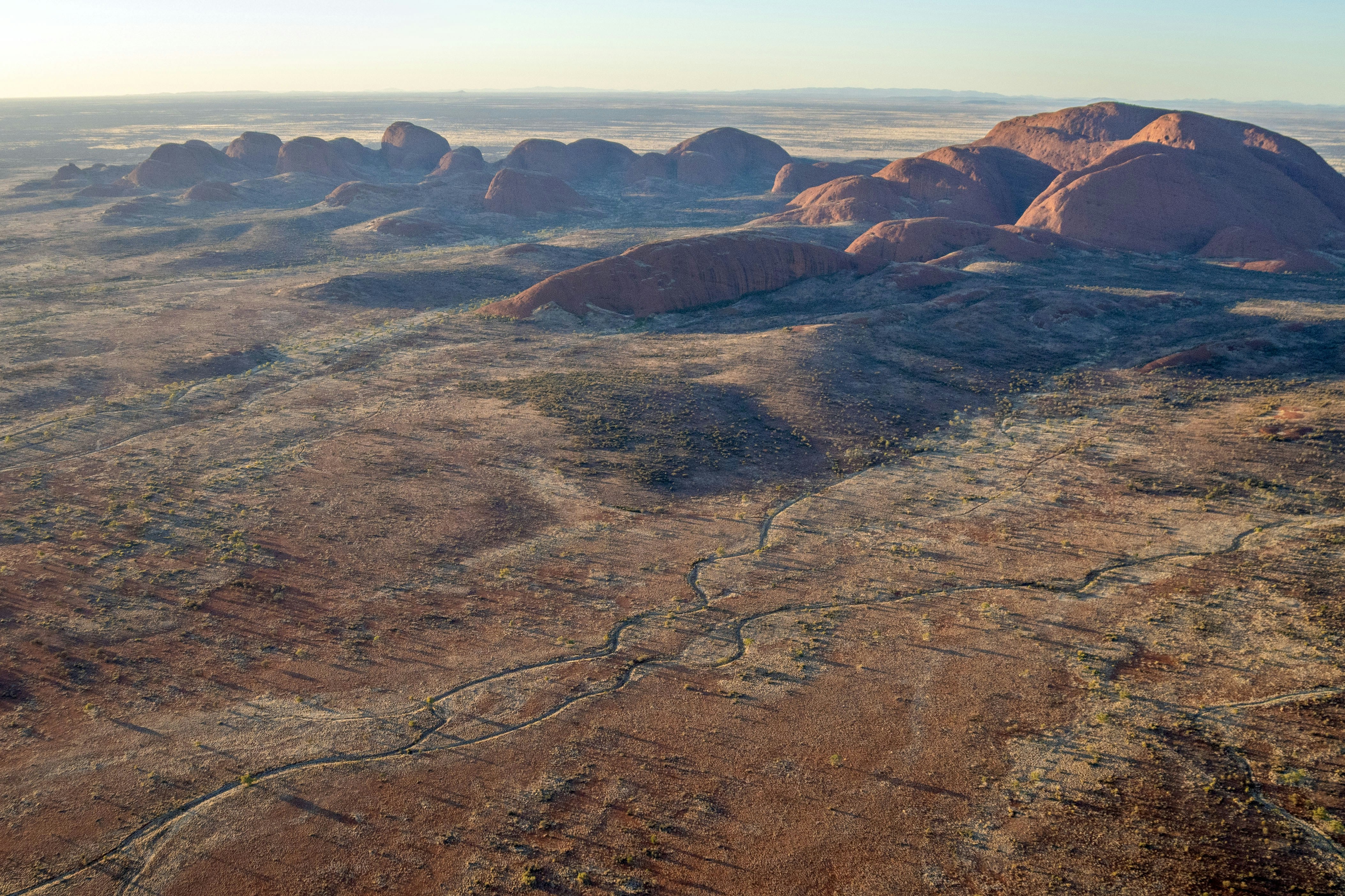 Vast desert landscape with large rock formations at sunrise