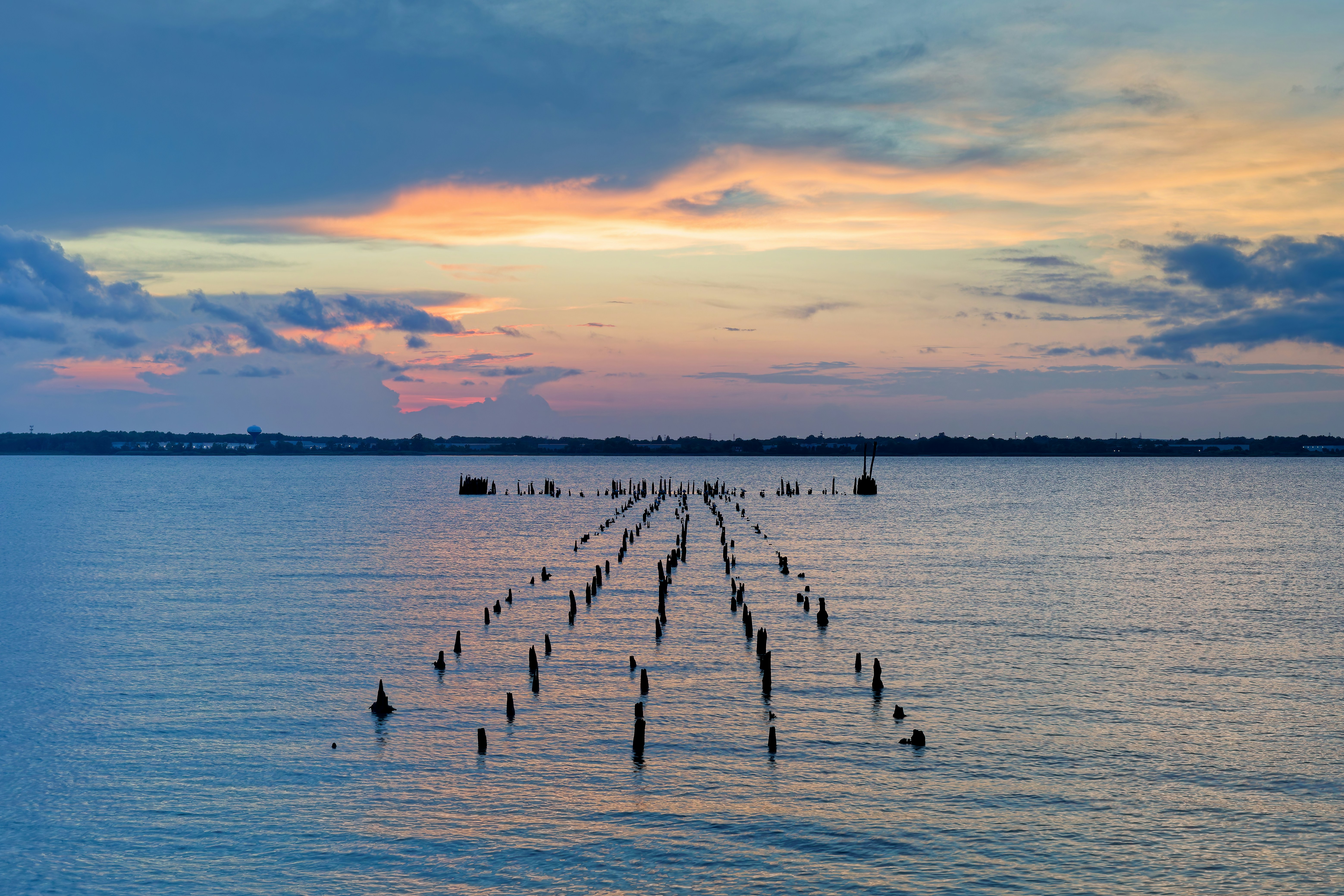 Wooden posts in the ocean at sunset photo – Free Sunset Image on Unsplash