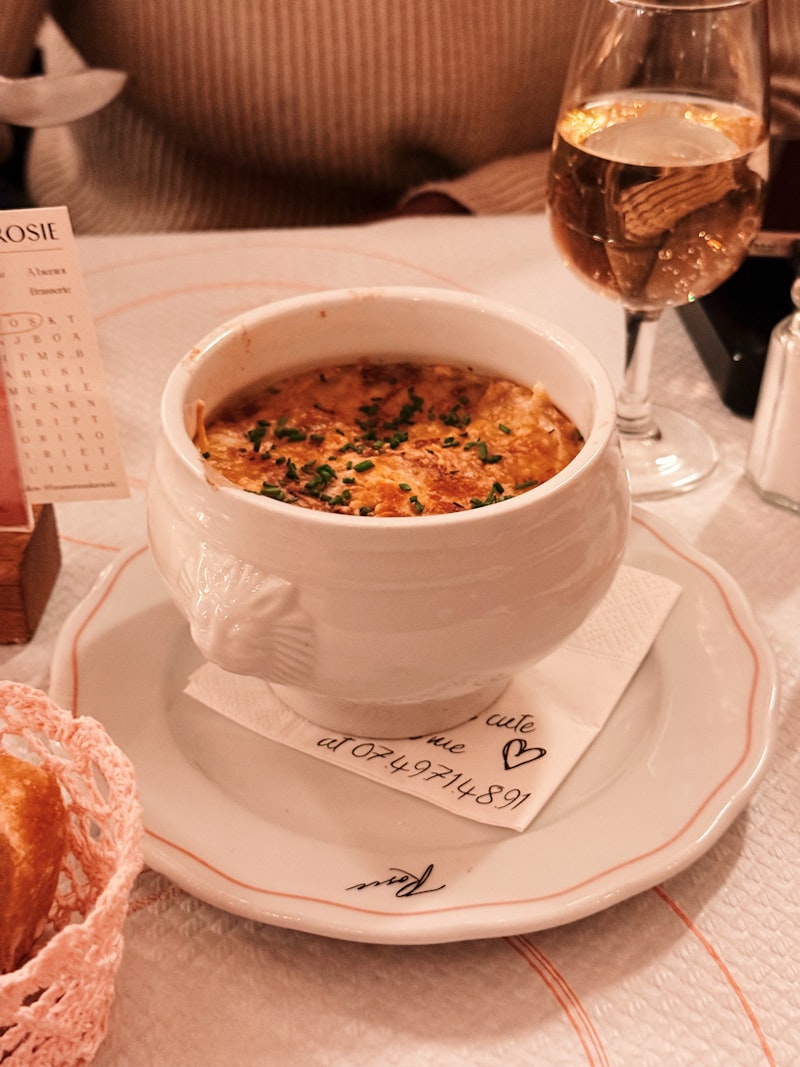 Onion soup with a browned cheese crust served in a white tureen