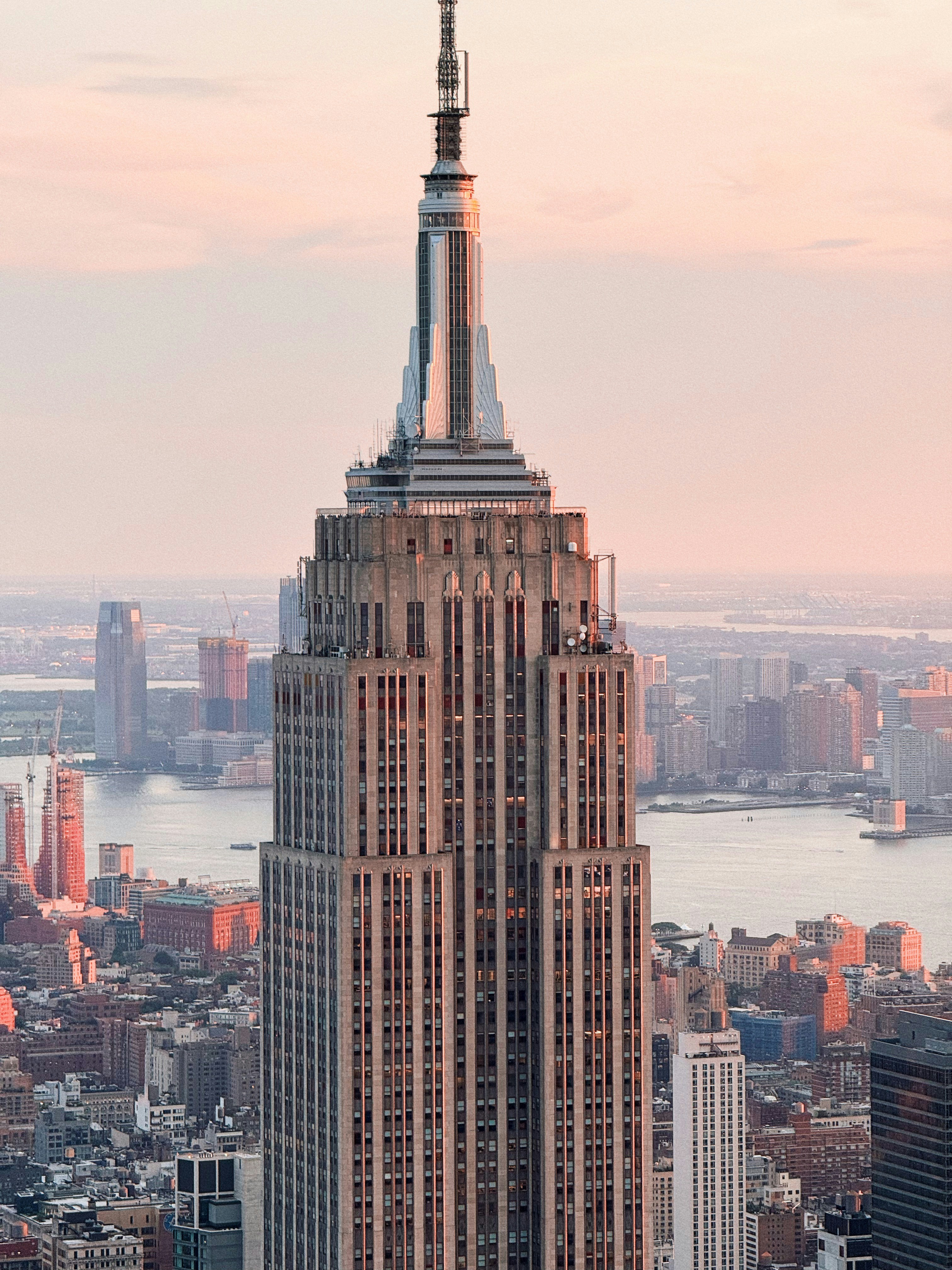 Empire state building at sunset with city skyline.