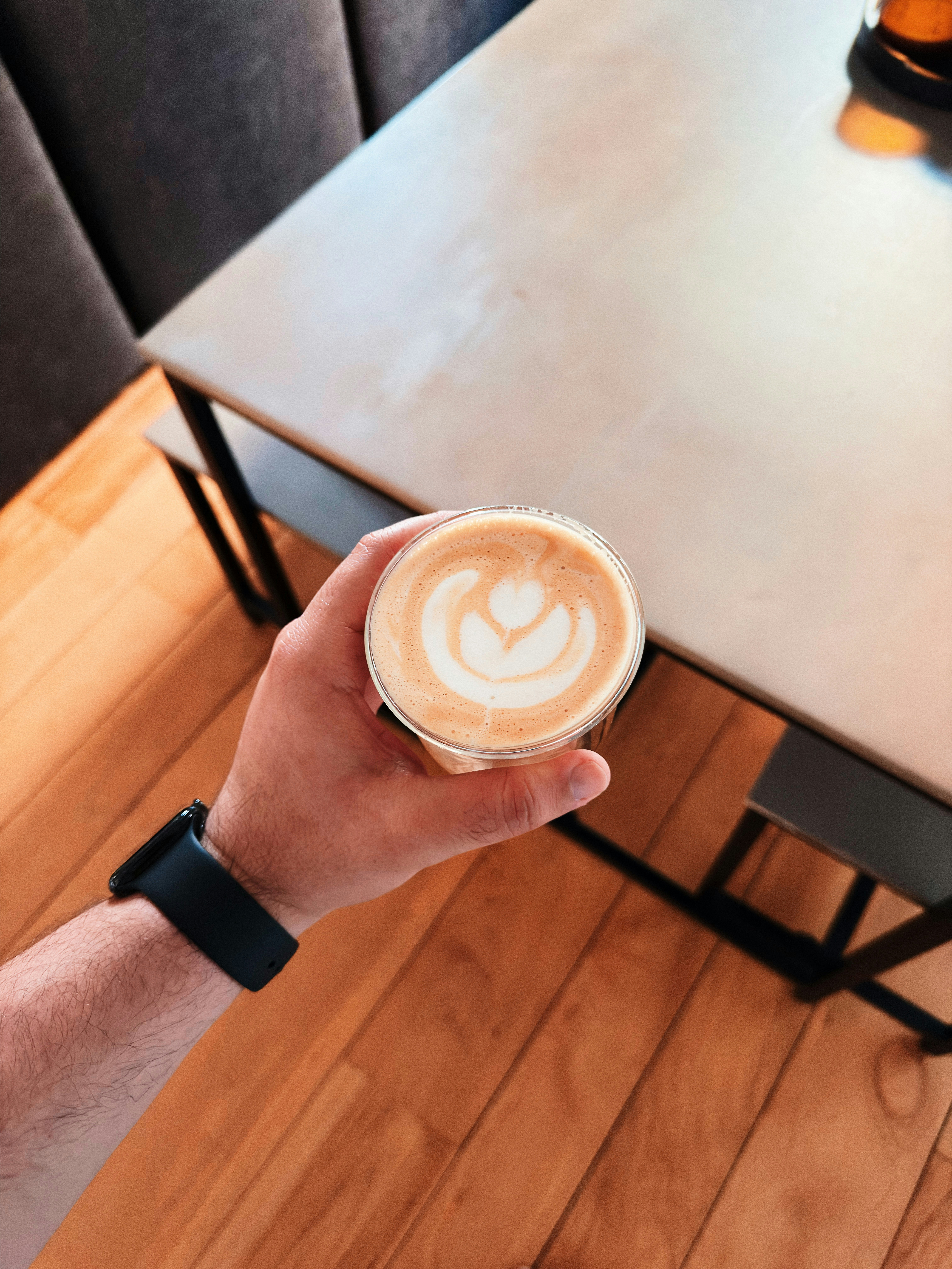 Hand holding a latte with heart art