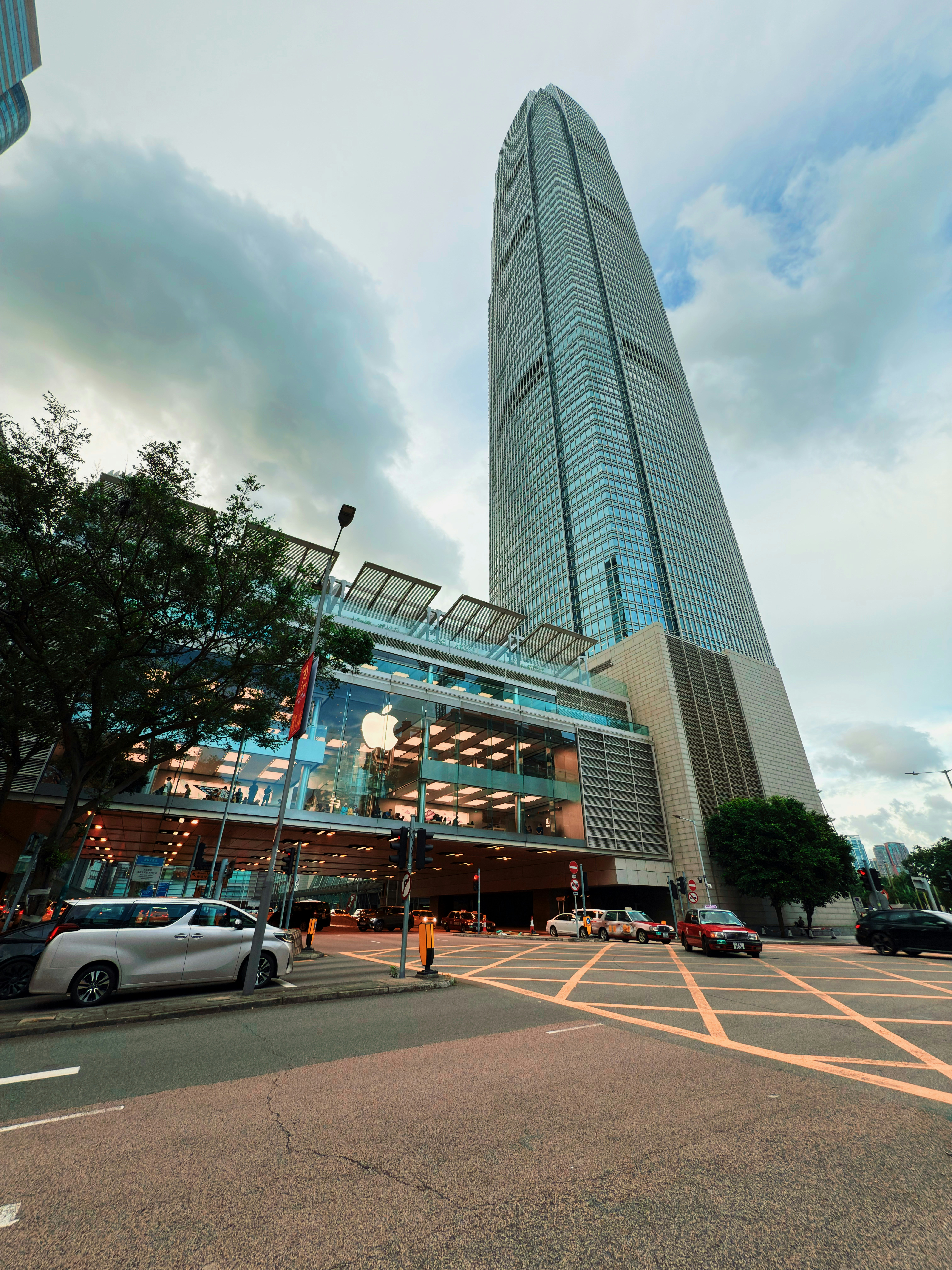 Modern skyscraper with glass facade and surrounding street.