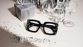 Black framed glasses with festive decorations on a table.