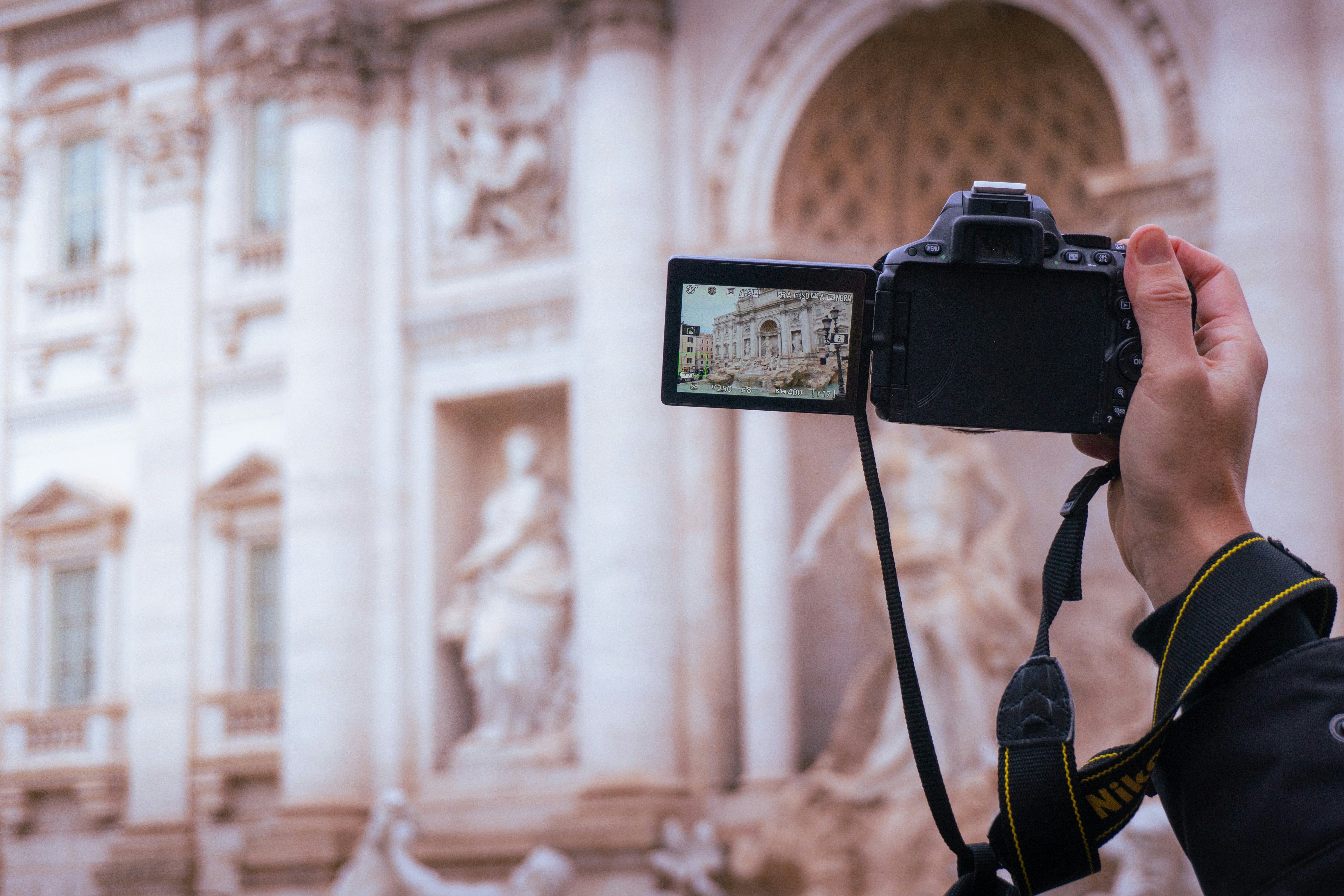 Hand holding camera photographing a building