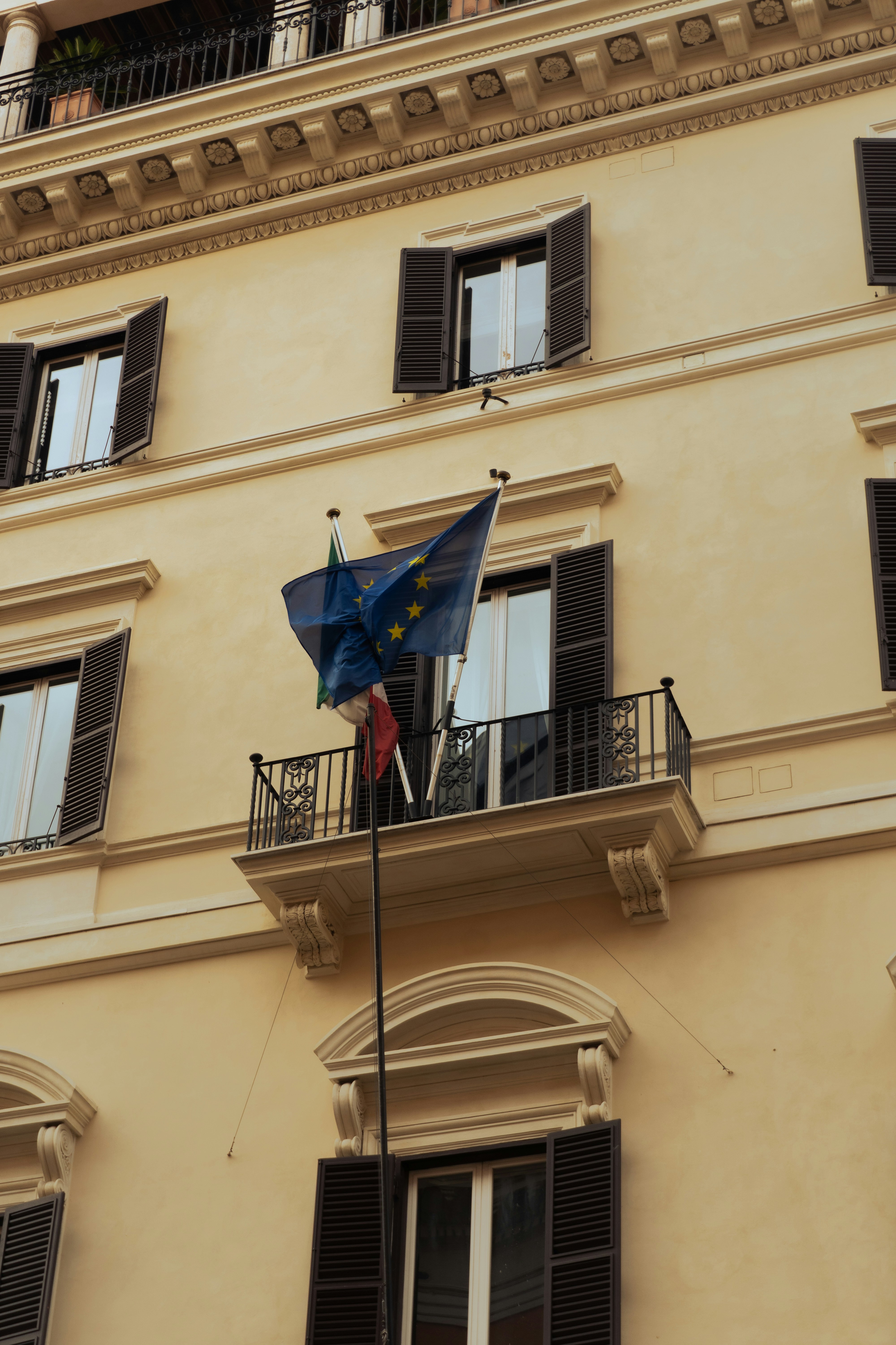 European union flag flying from a building balcony.