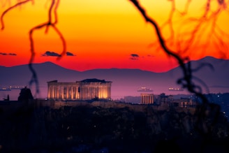 The acropolis of athens at sunset with vibrant sky.