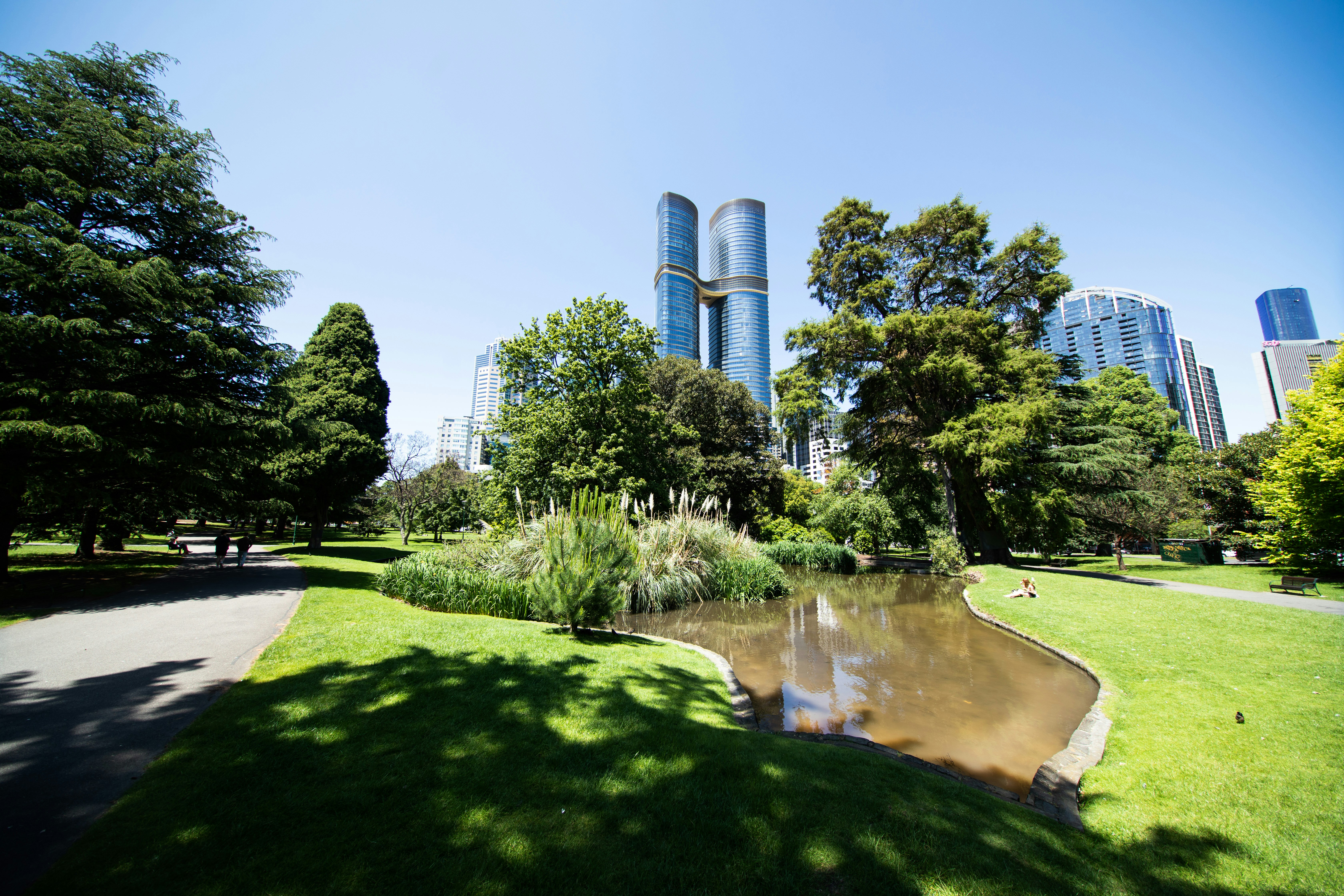 City skyline seen from a lush green park with pond