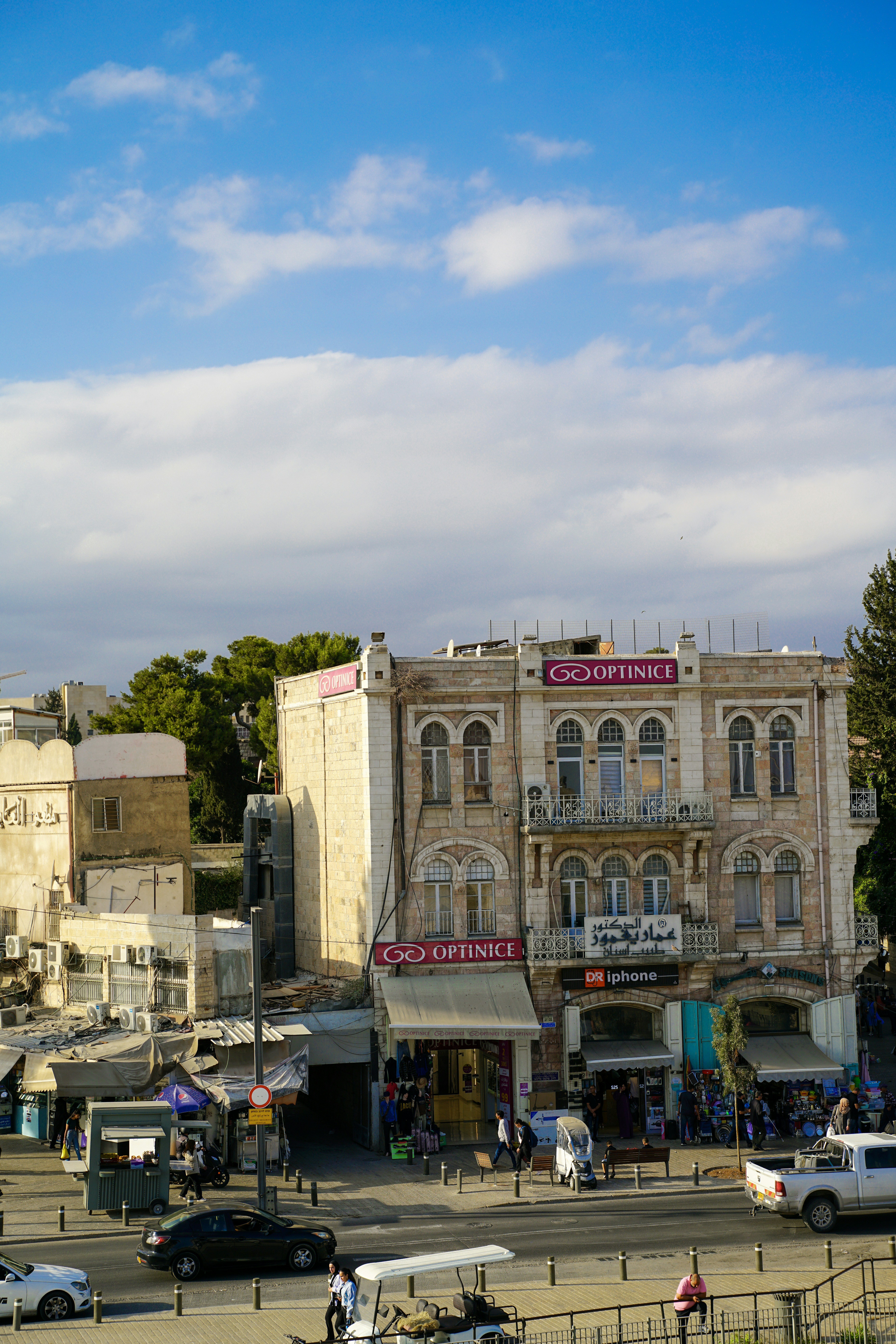 Buildings and shops along a street under blue sky