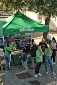 People gathered around a green greenpeace information tent.