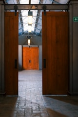 Two large wooden barn doors open into a hall.