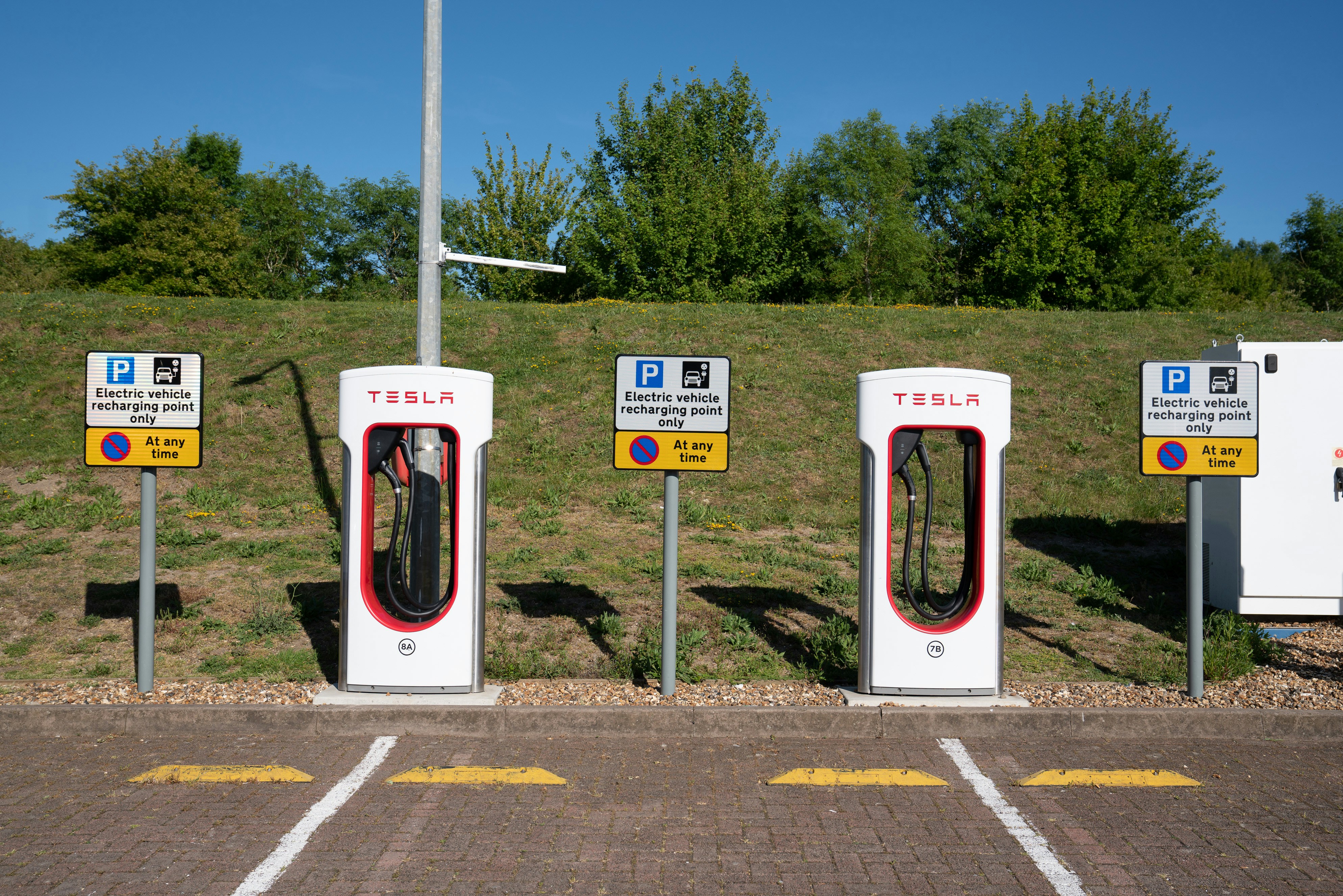 silver tesla cybertruck parked at supercharger station