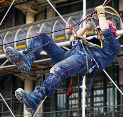 A person rappels down a building with safety gear