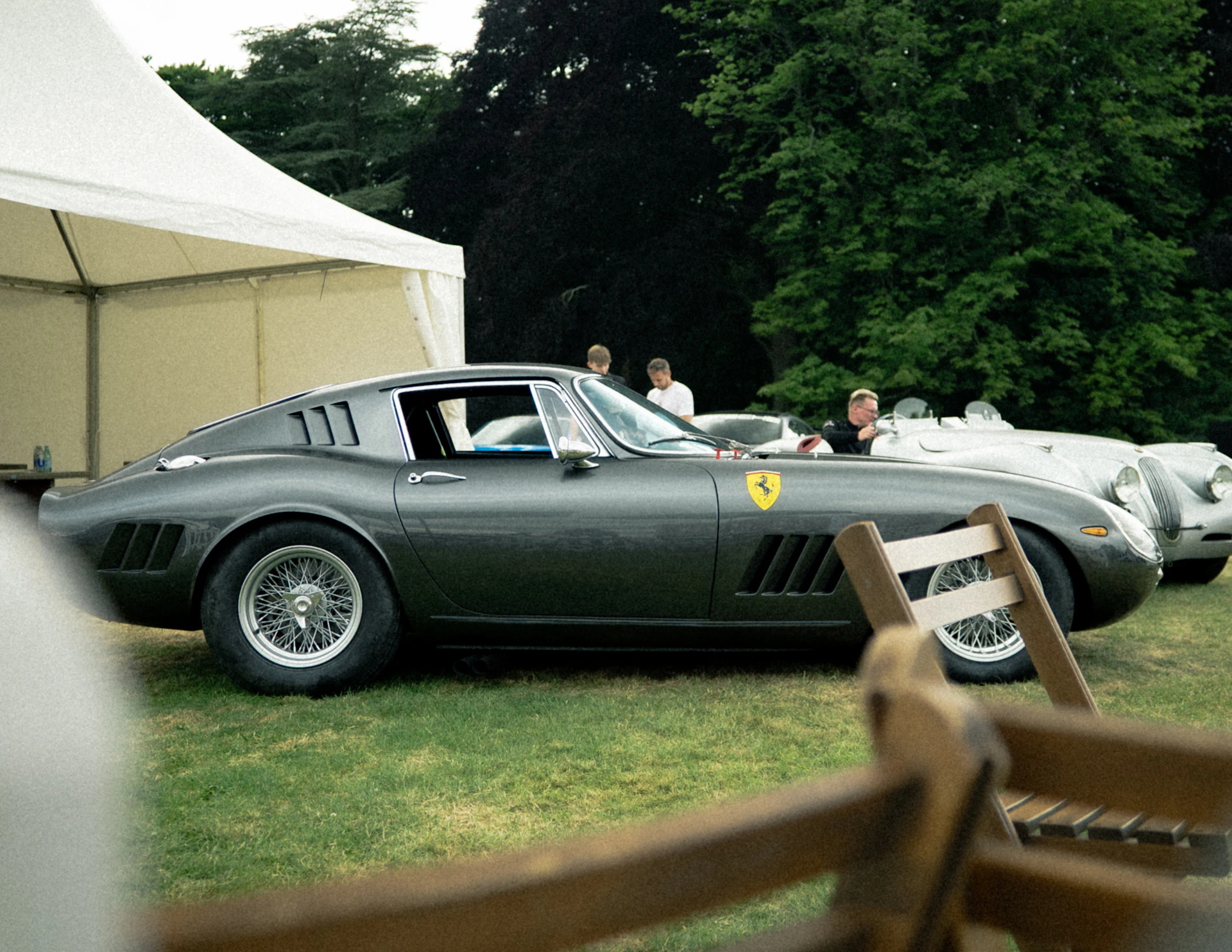 A classic grey Ferrari at an outdoor collector-car gathering