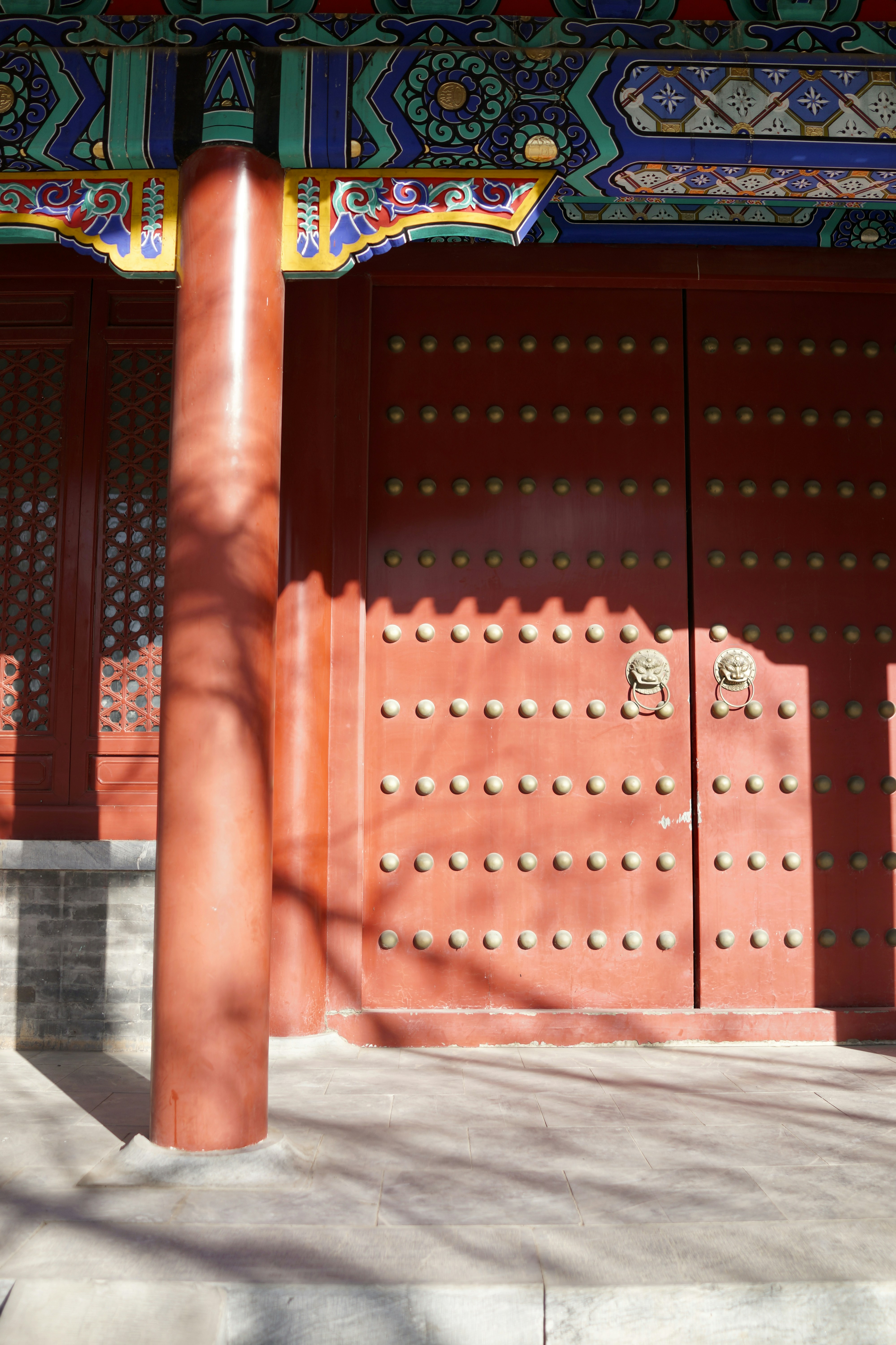 Traditional red doors with ornate details and brass knockers.