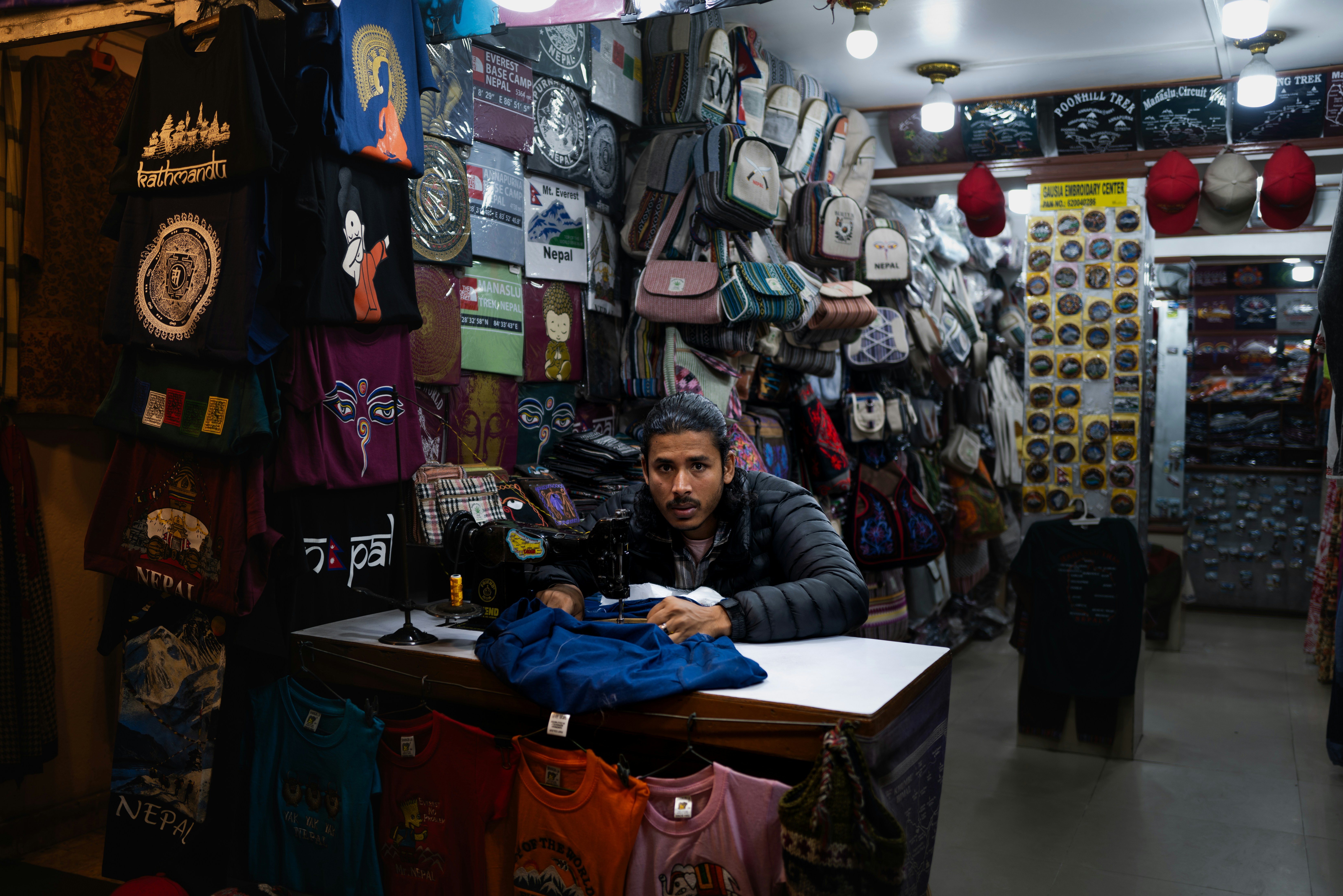 Man sitting at a counter in a crowded shop