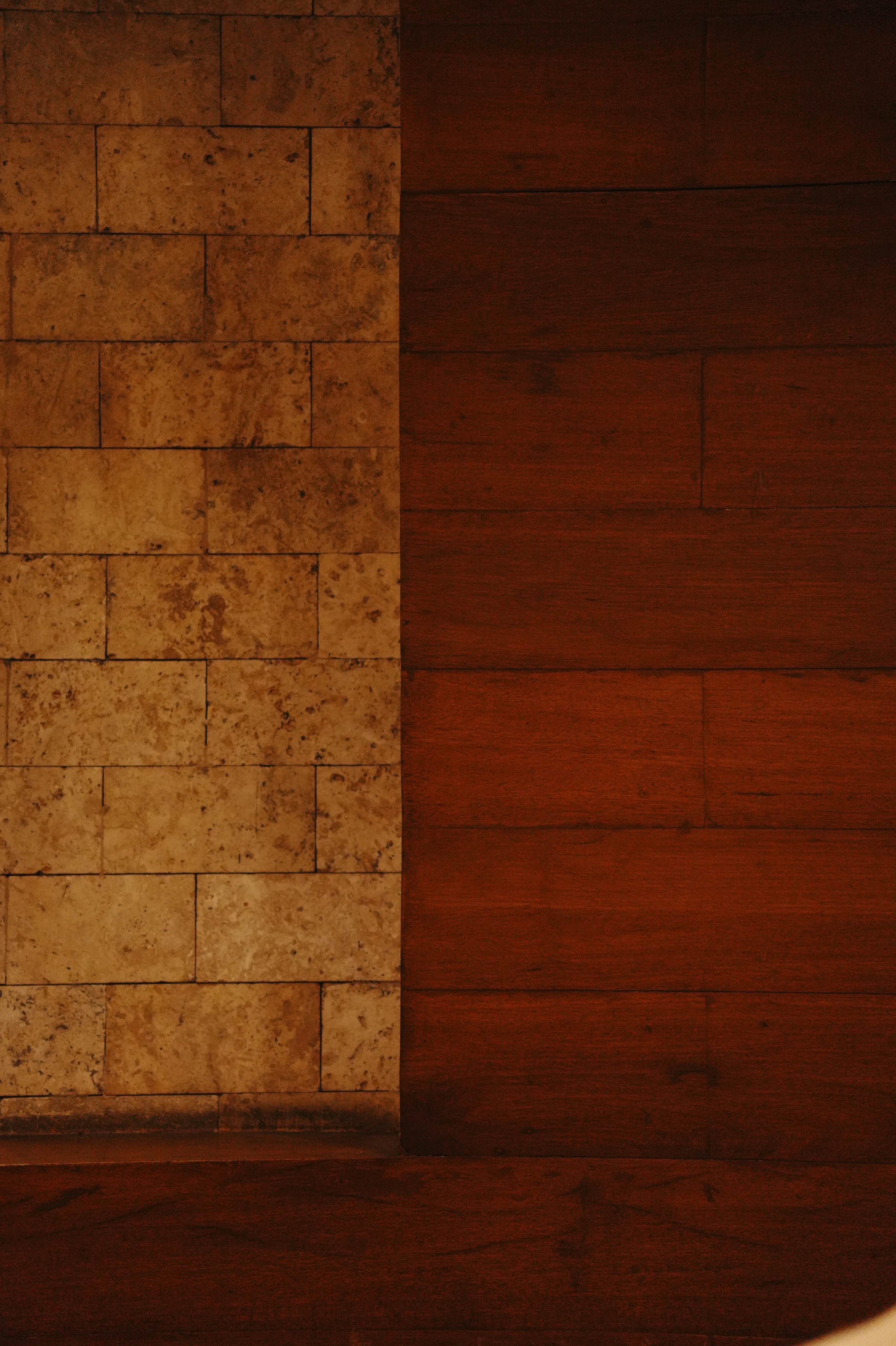 Architectural detail showing stone and warm natural wood textures in a minimalist luxury interior