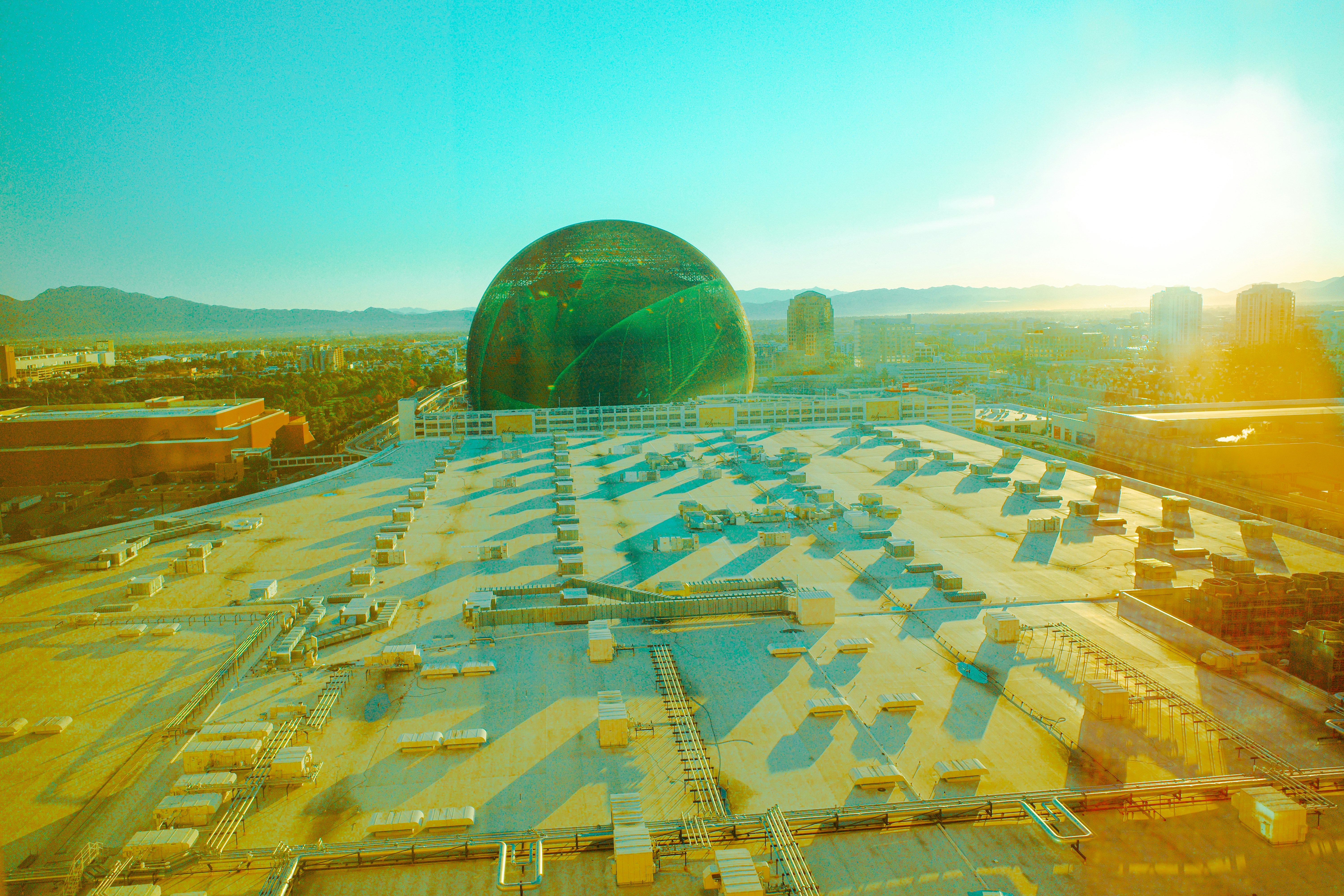 Large green dome building with rows of solar panels.