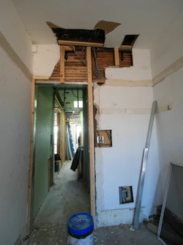 Interior room undergoing renovation with exposed walls and doorway