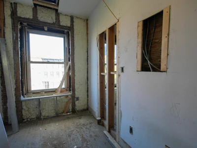 Interior room undergoing renovation with exposed walls and window