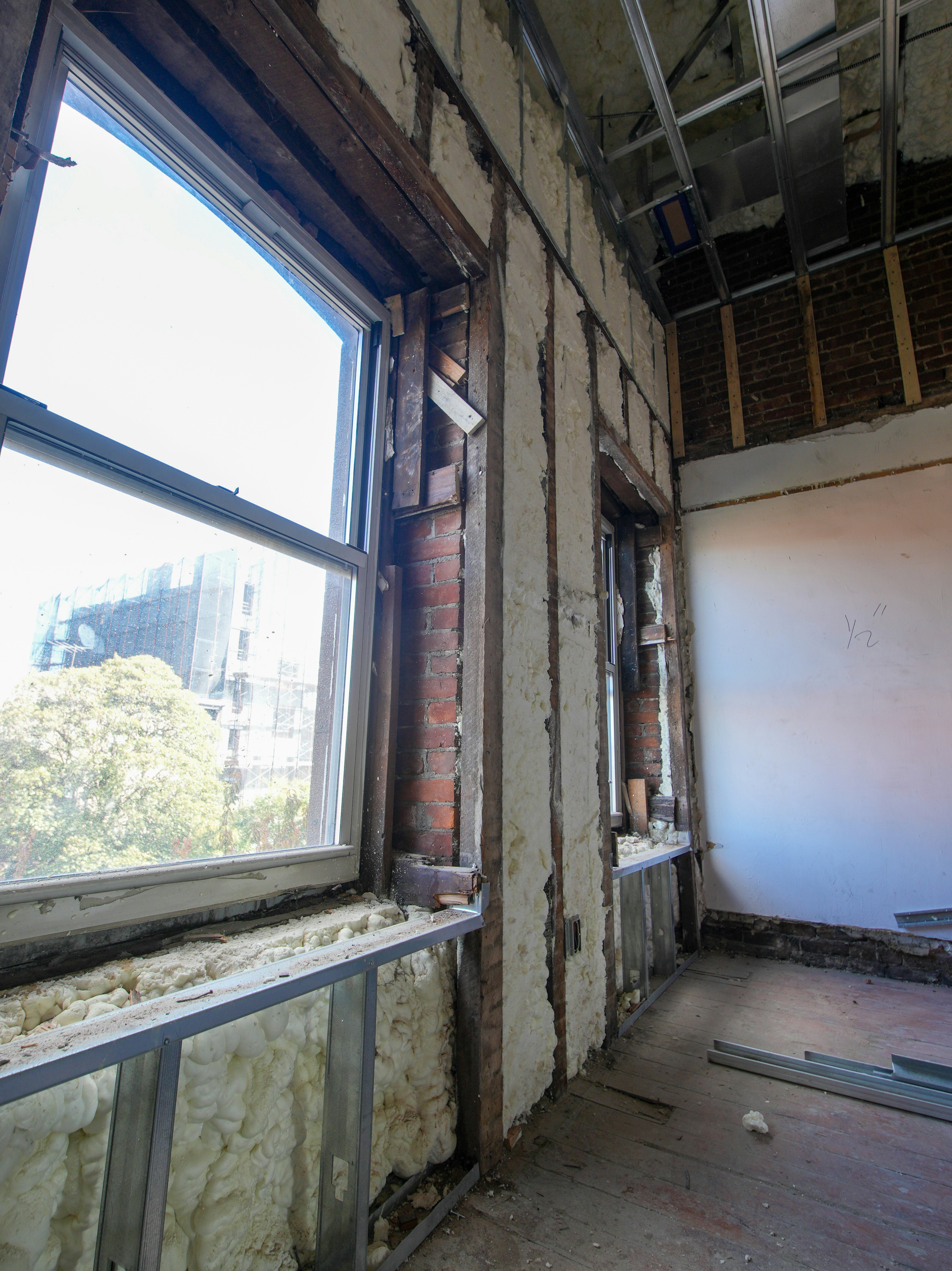 Interior room under construction with exposed brick and insulation