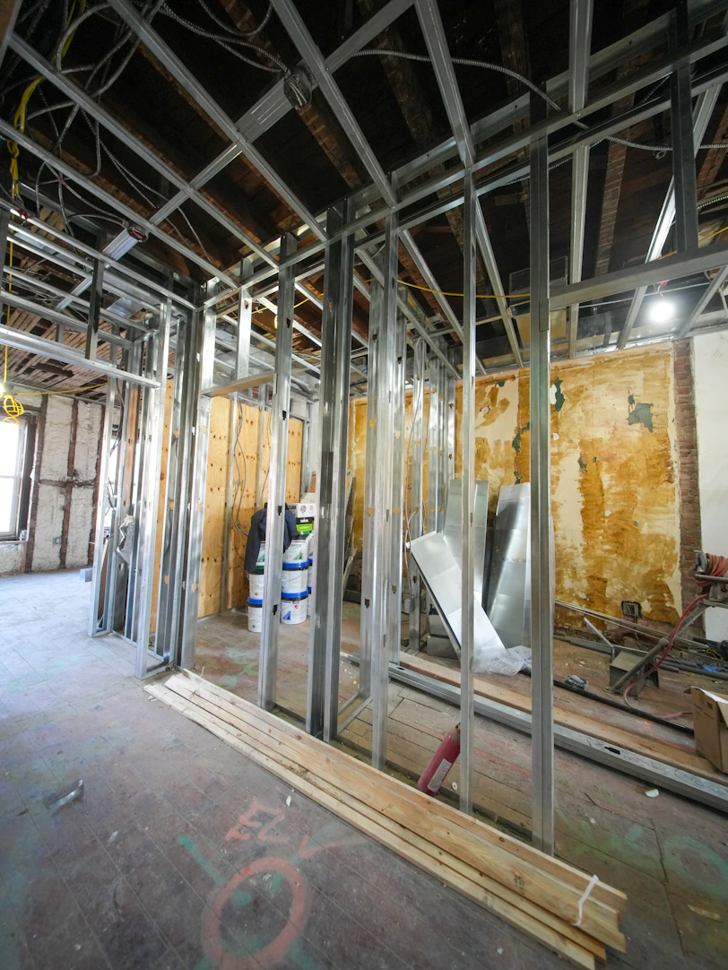 Interior construction with metal studs and exposed ceiling.