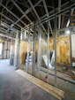 Interior construction with metal studs and exposed ceiling.