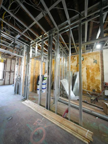 Interior construction with metal studs and exposed ceiling.