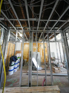 Interior construction with metal studs and exposed ceiling.