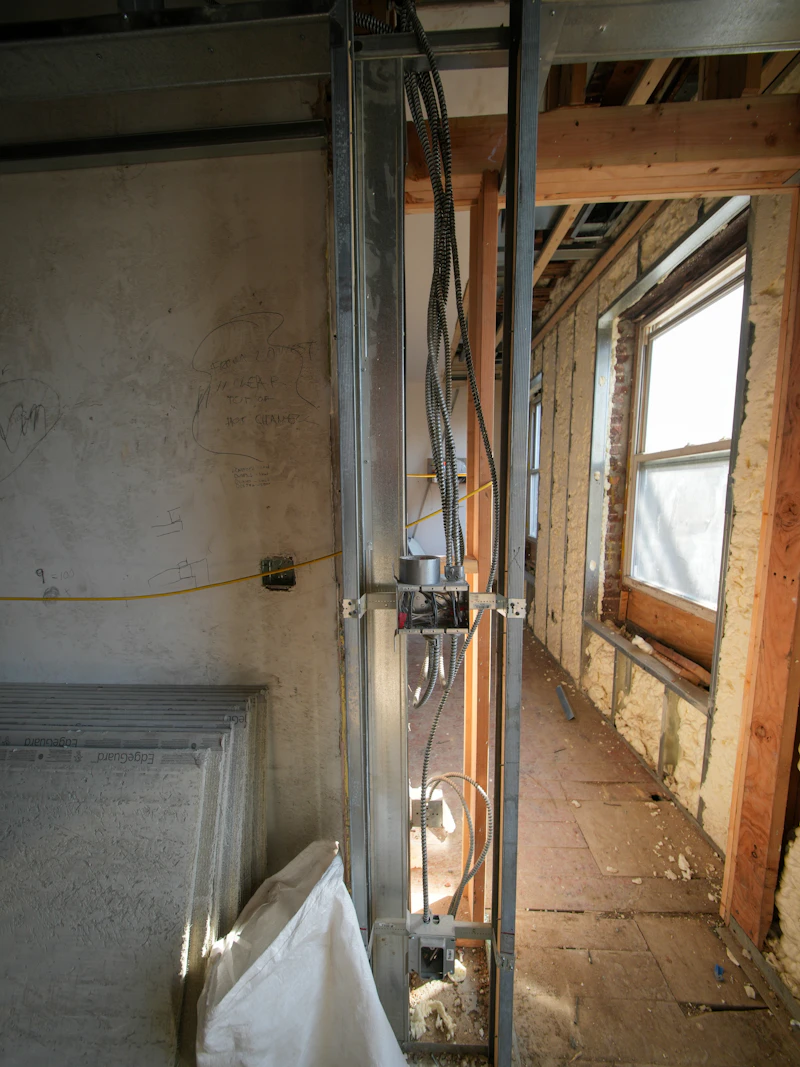 Construction hallway with exposed wiring and studs