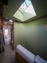 Room under construction with skylight and blueprints.