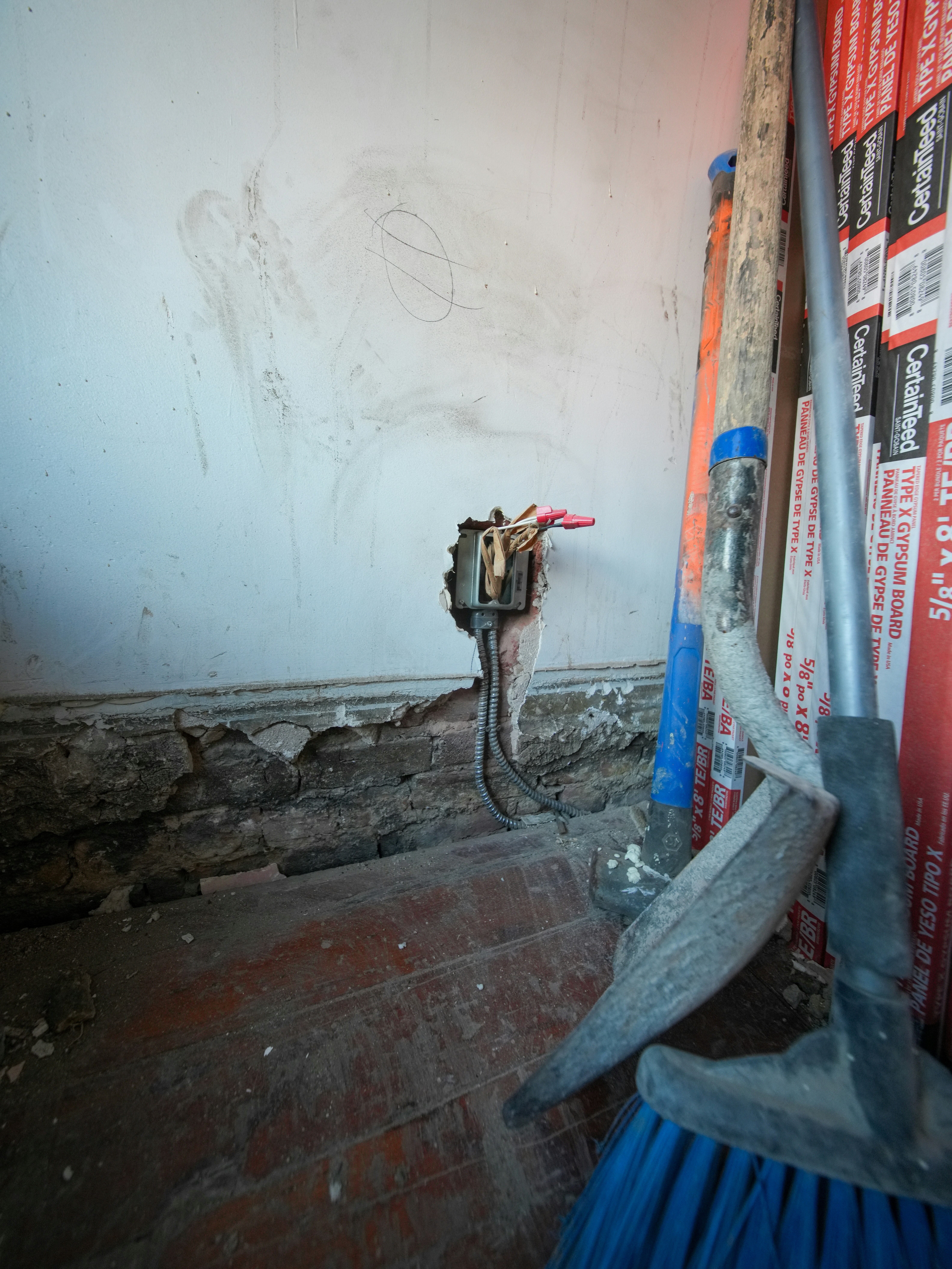 Werkzeuge und freiliegende Kabel an einer Wand