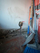 Tools and exposed wiring against a wall
