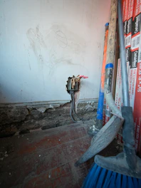 Tools and exposed wiring against a wall