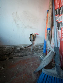 Tools and exposed wiring against a wall